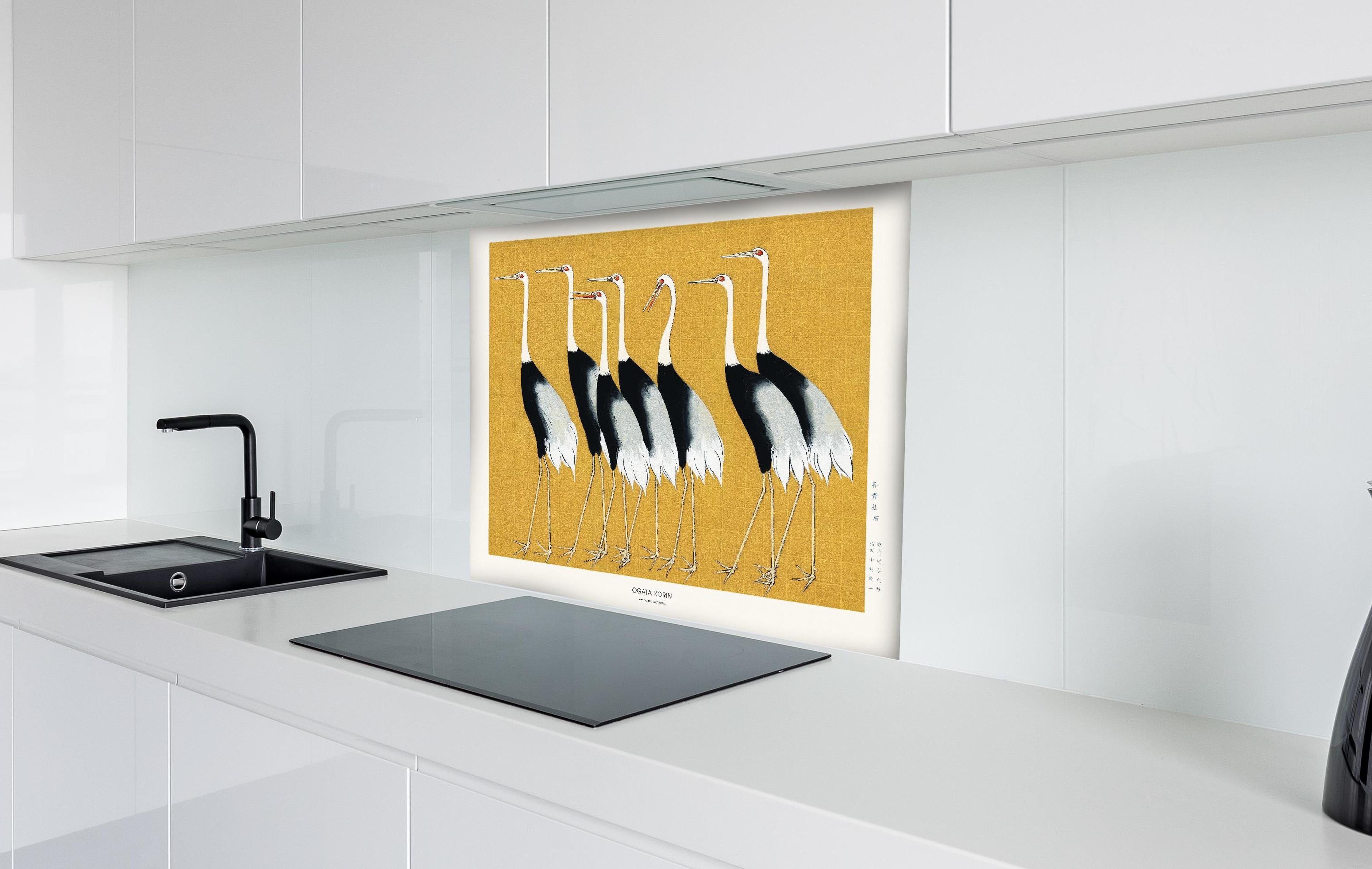 Spritzschutz - Japanischer Mandschurenkranich - Gold hinter einem Cerankochfeld zwischen Holz-Kochutensilien