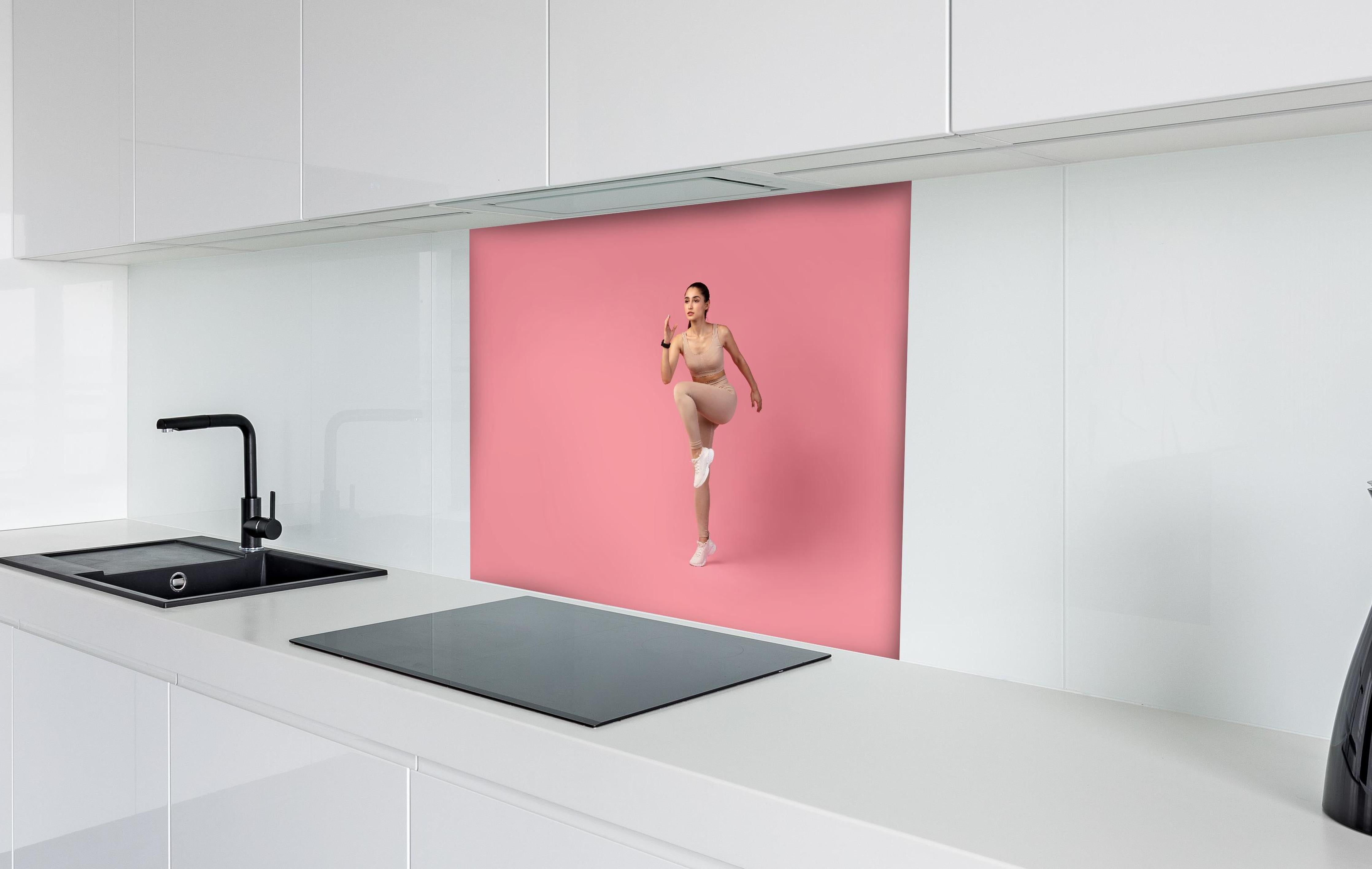 Spritzschutz - Junge Fitness Frau in Läuferpose hinter einem Cerankochfeld zwischen Holz-Kochutensilien