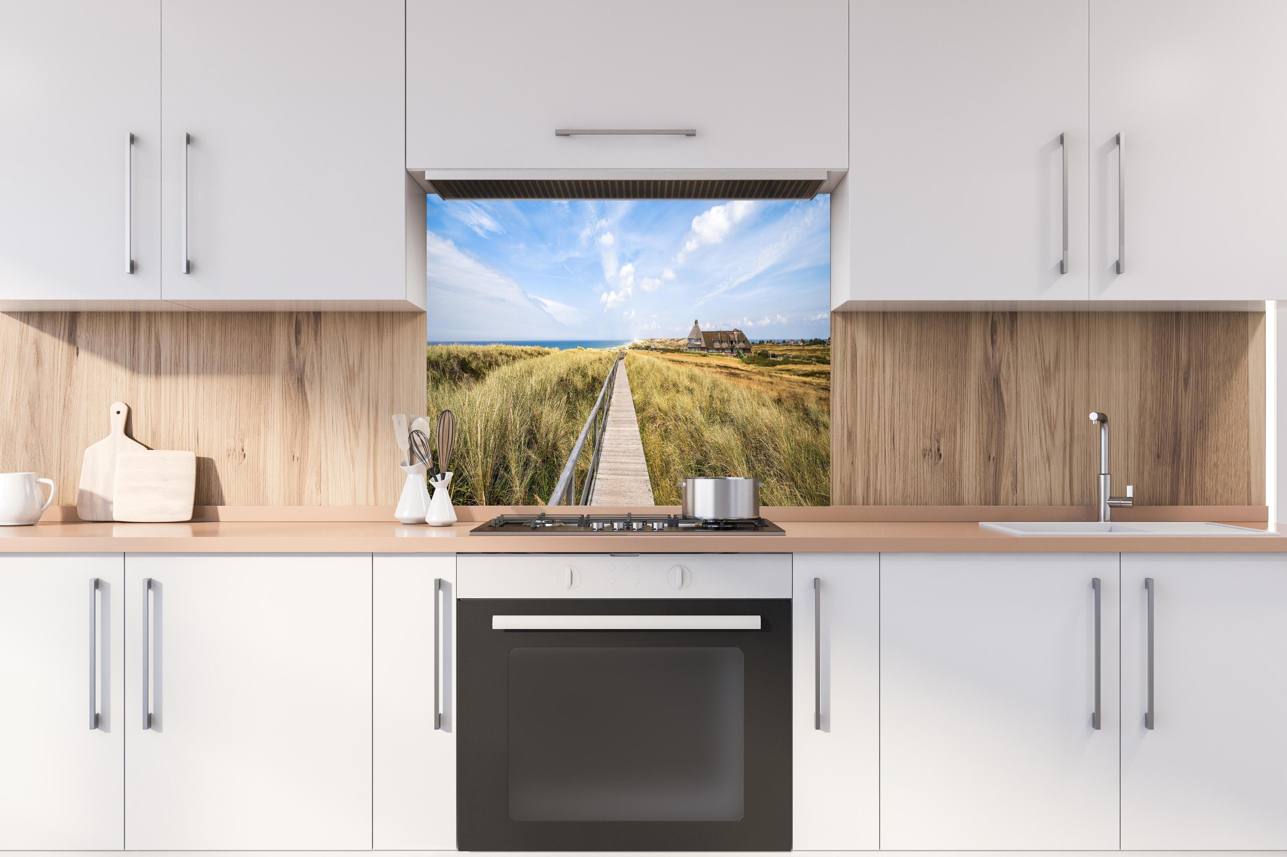 Spritzschutz - Kampen Landschaft hinter einem Cerankochfeld zwischen Holz-Kochutensilien