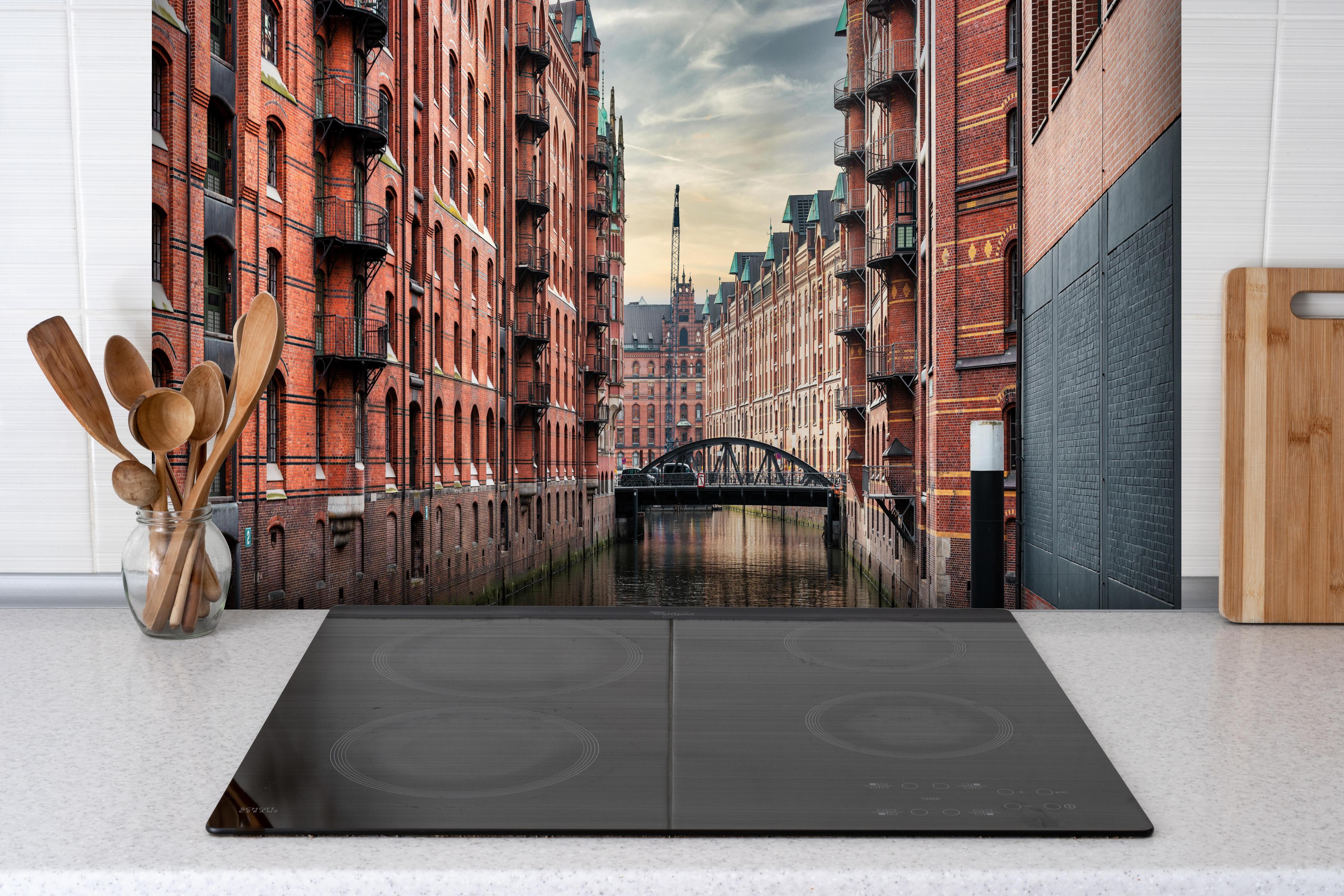 Spritzschutz - Kanal in der alten Speicherstadt hinter einem Cerankochfeld zwischen Holz-Kochutensilien