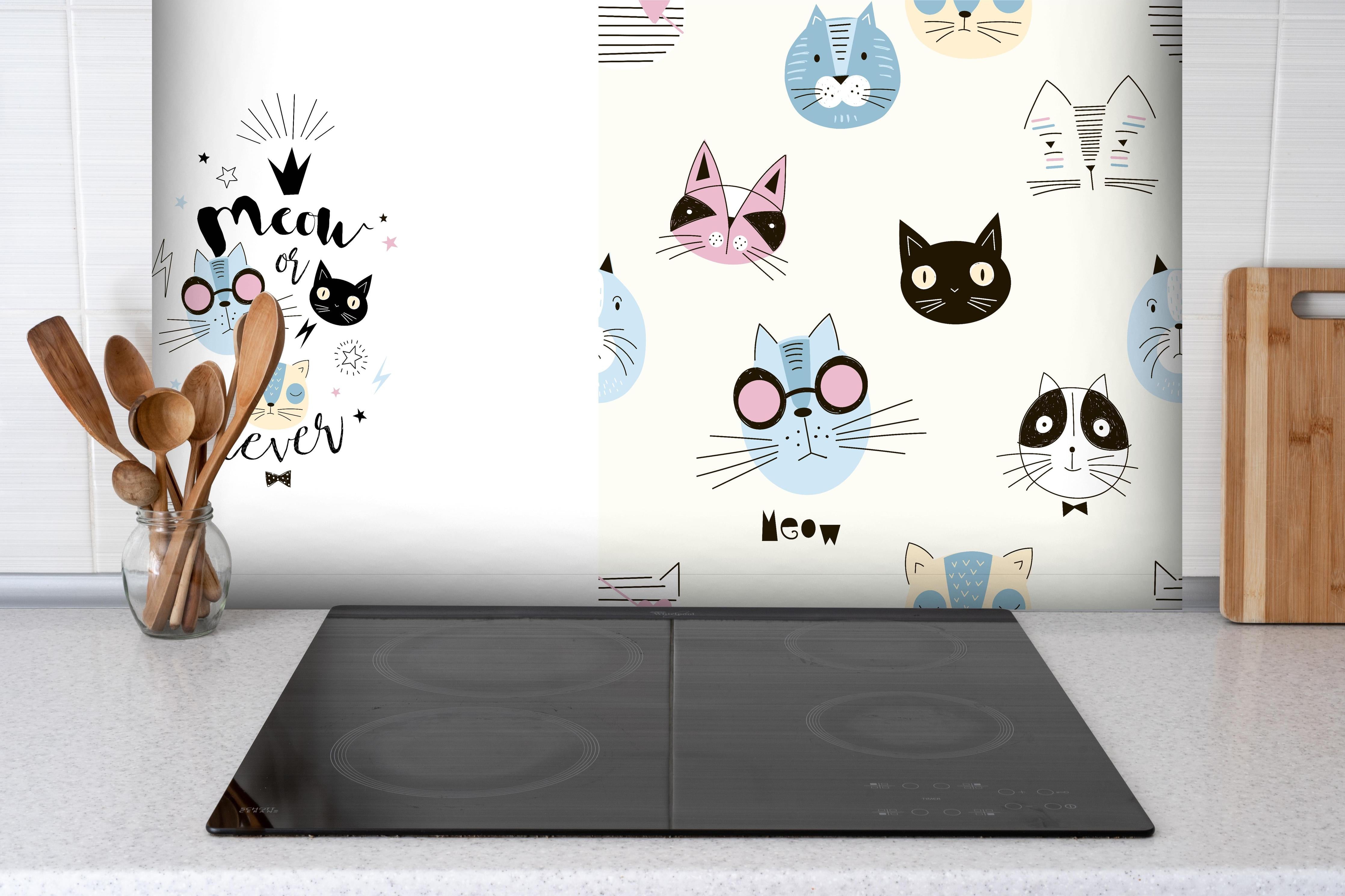 Spritzschutz - Katzen-Muster Schlafanzug-Set für Kinder hinter einem Cerankochfeld zwischen Holz-Kochutensilien