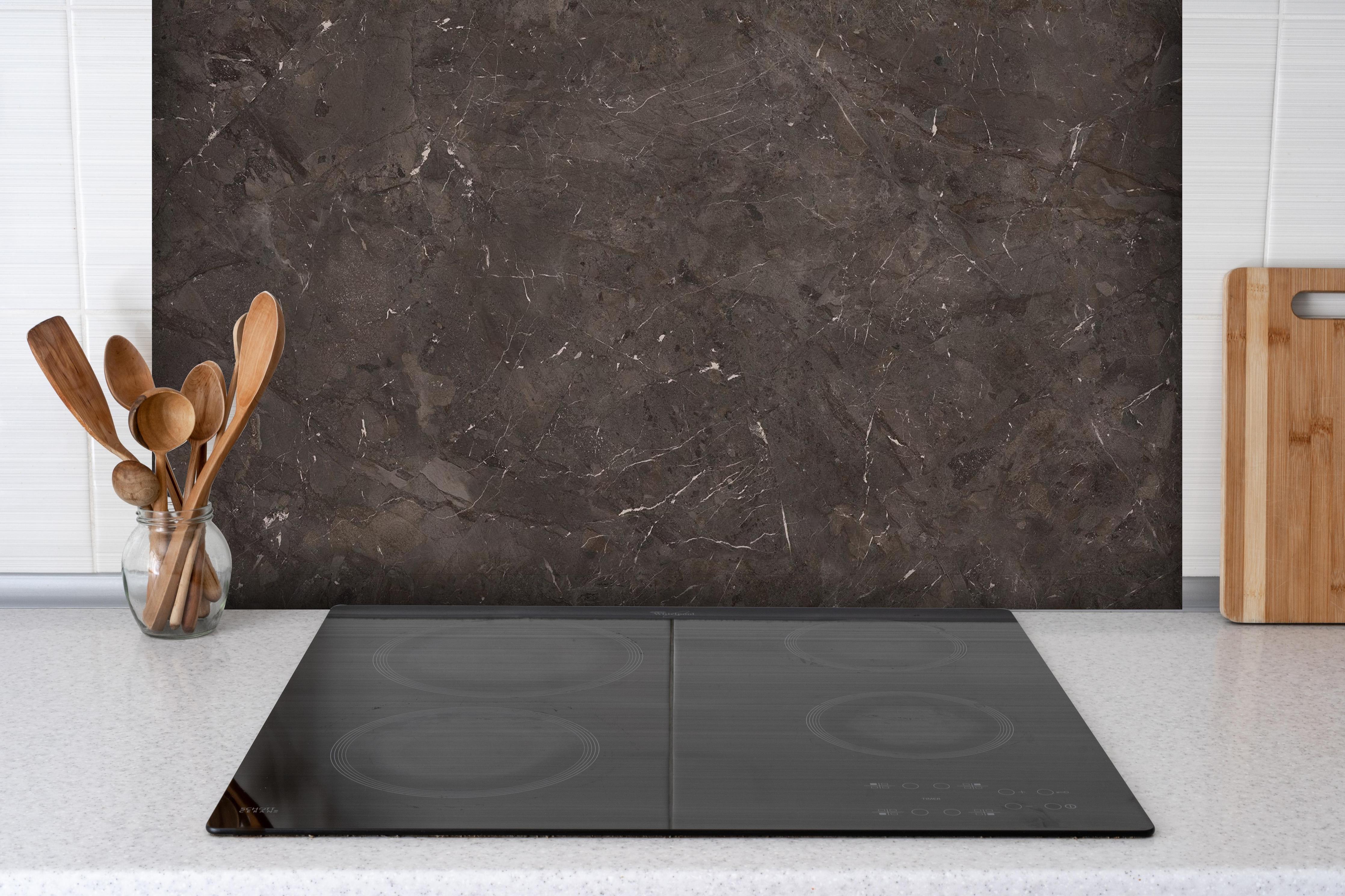 Spritzschutz - Keramik Desert Brown hinter einem Cerankochfeld zwischen Holz-Kochutensilien