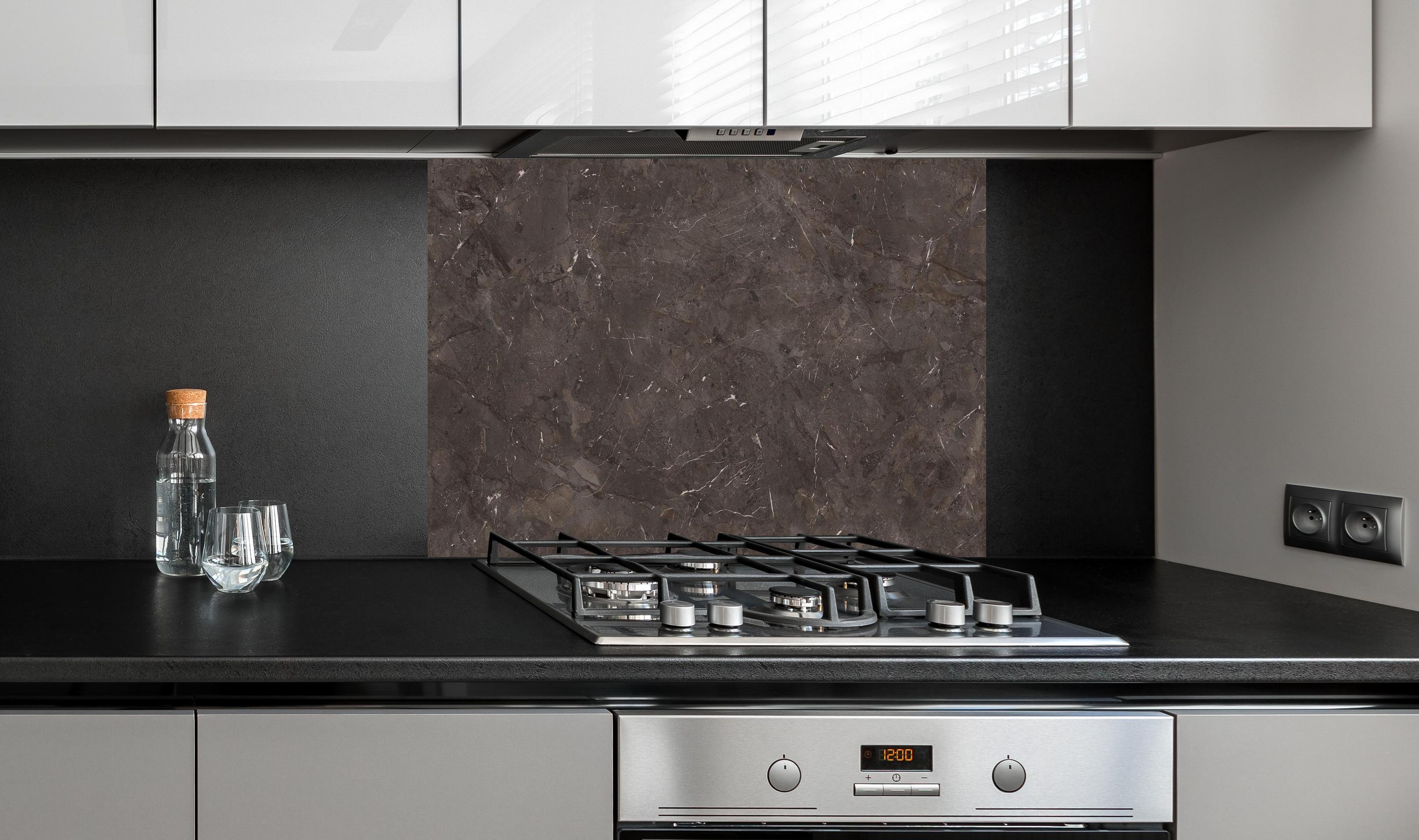 Spritzschutz - Keramik Desert Brown hinter einem Cerankochfeld zwischen Holz-Kochutensilien