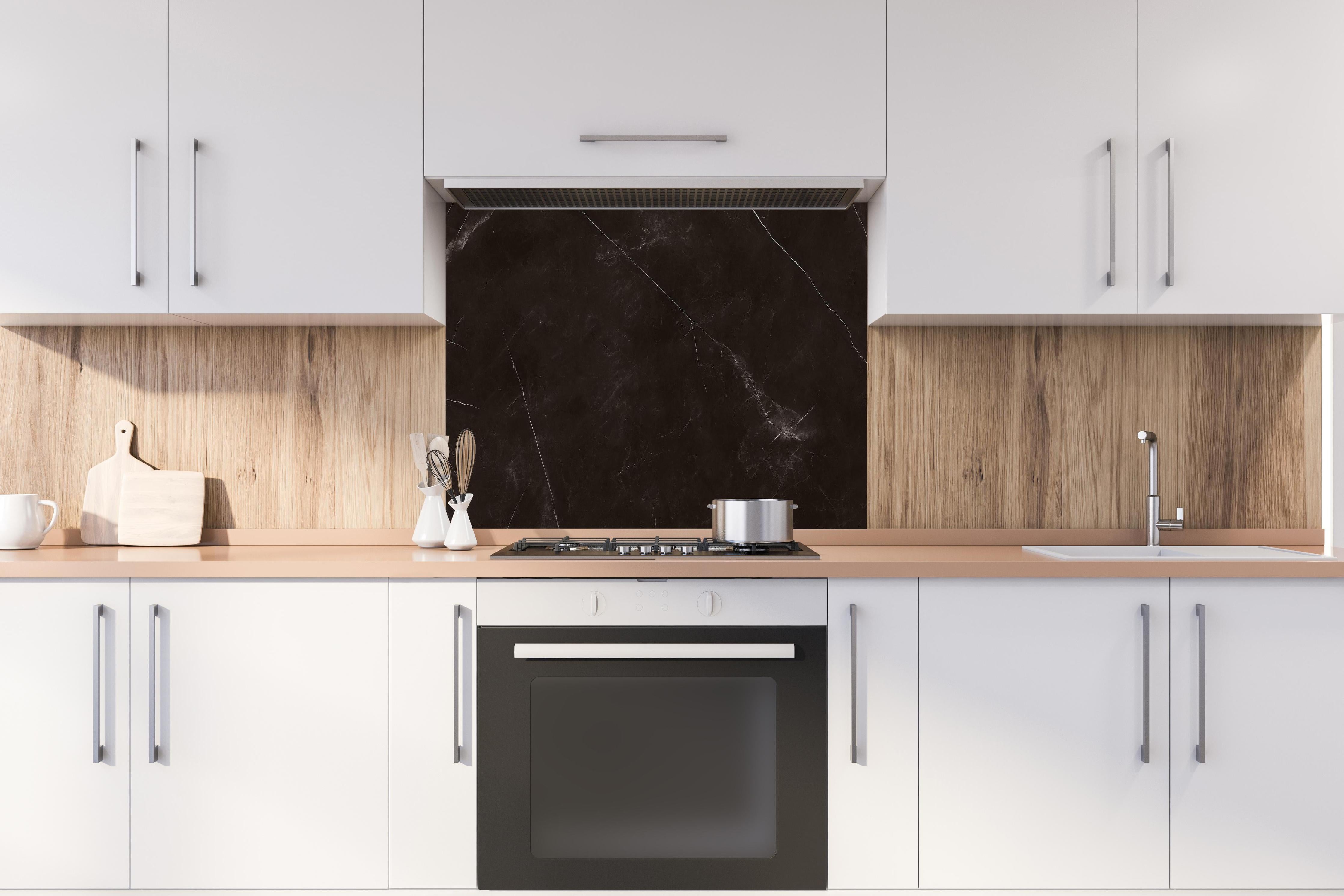 Spritzschutz - Keramik Tempest Black hinter einem Cerankochfeld zwischen Holz-Kochutensilien