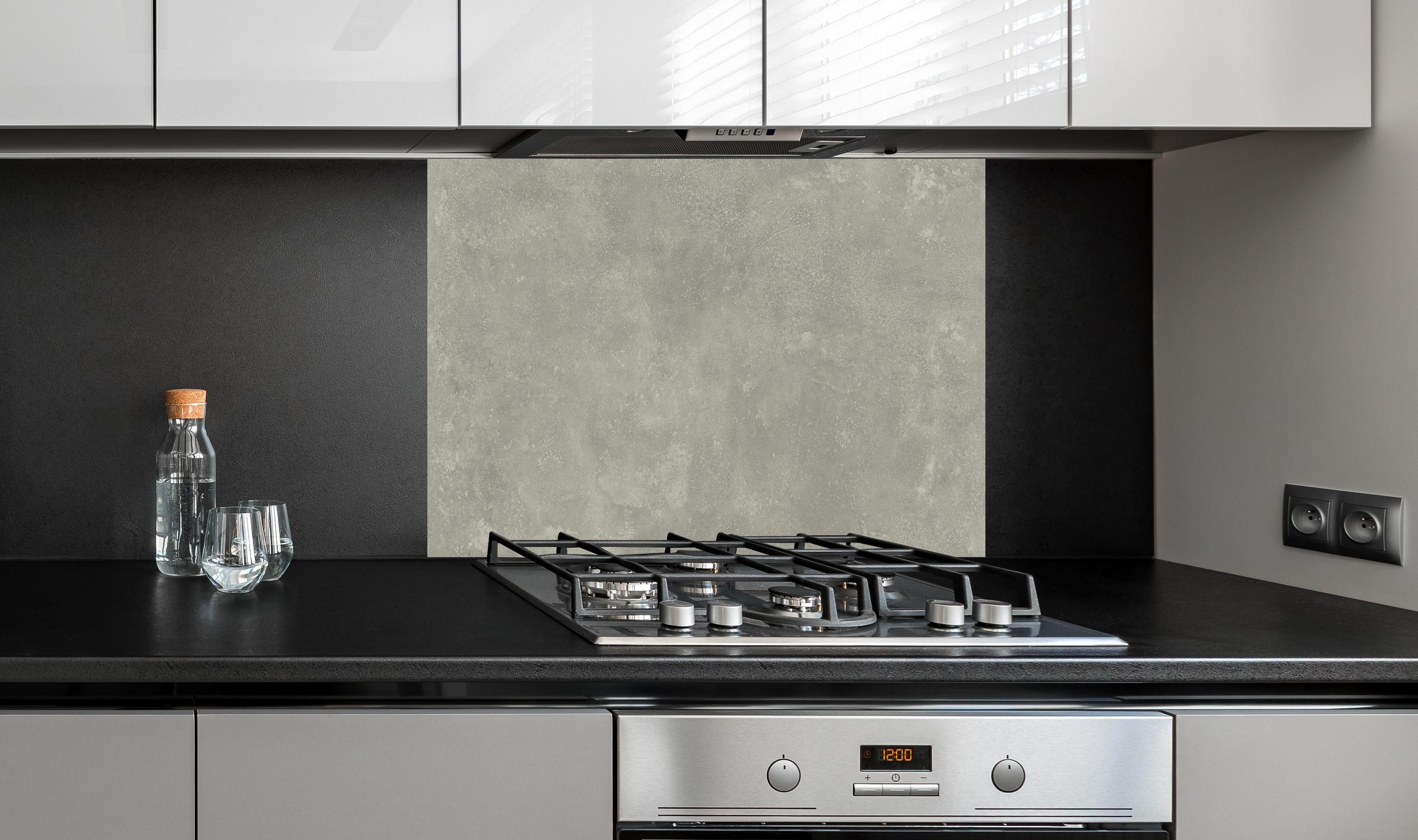 Spritzschutz - Keramik Urban Grey hinter einem Cerankochfeld zwischen Holz-Kochutensilien