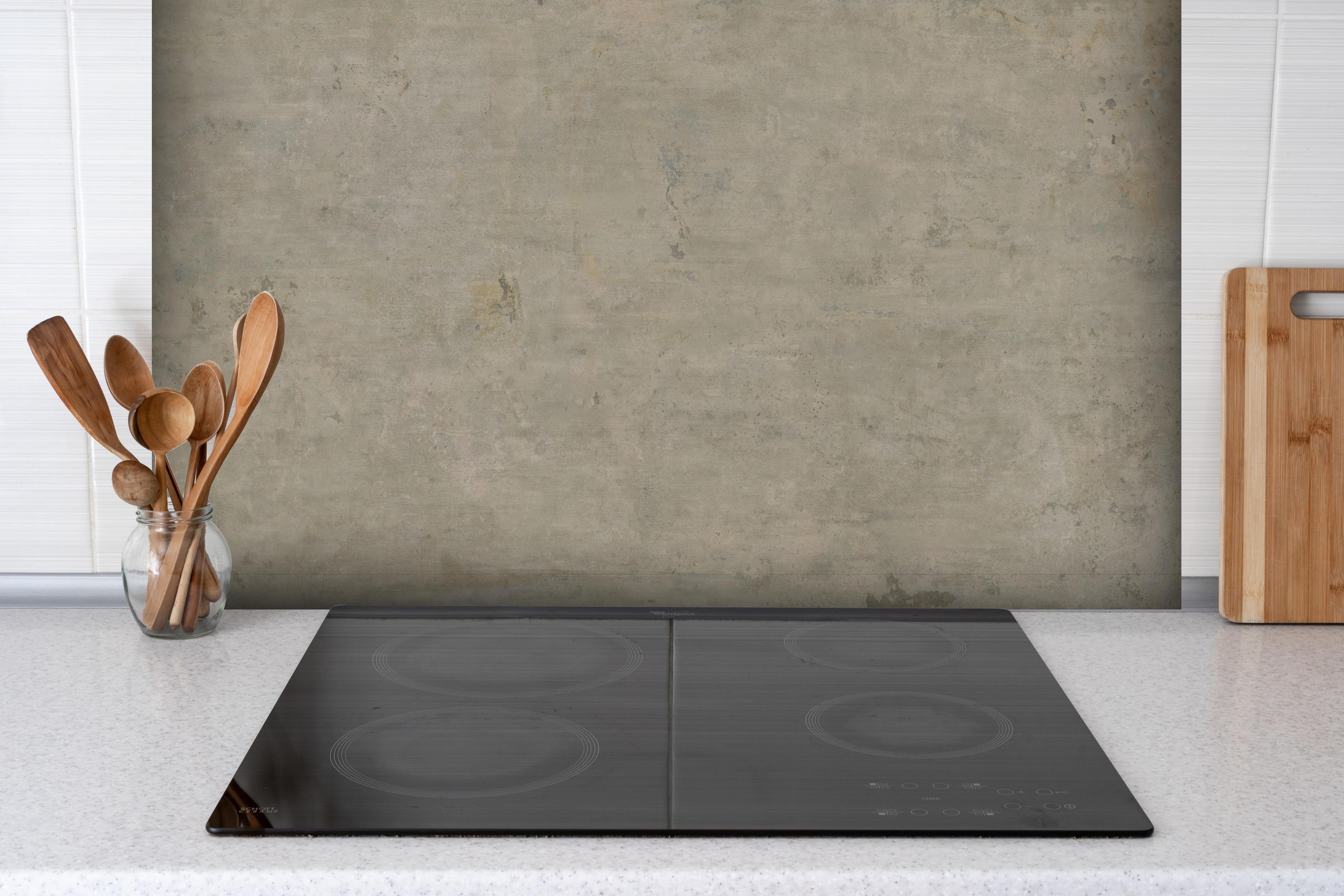 Spritzschutz - Keramik Urban Stone hinter einem Cerankochfeld zwischen Holz-Kochutensilien