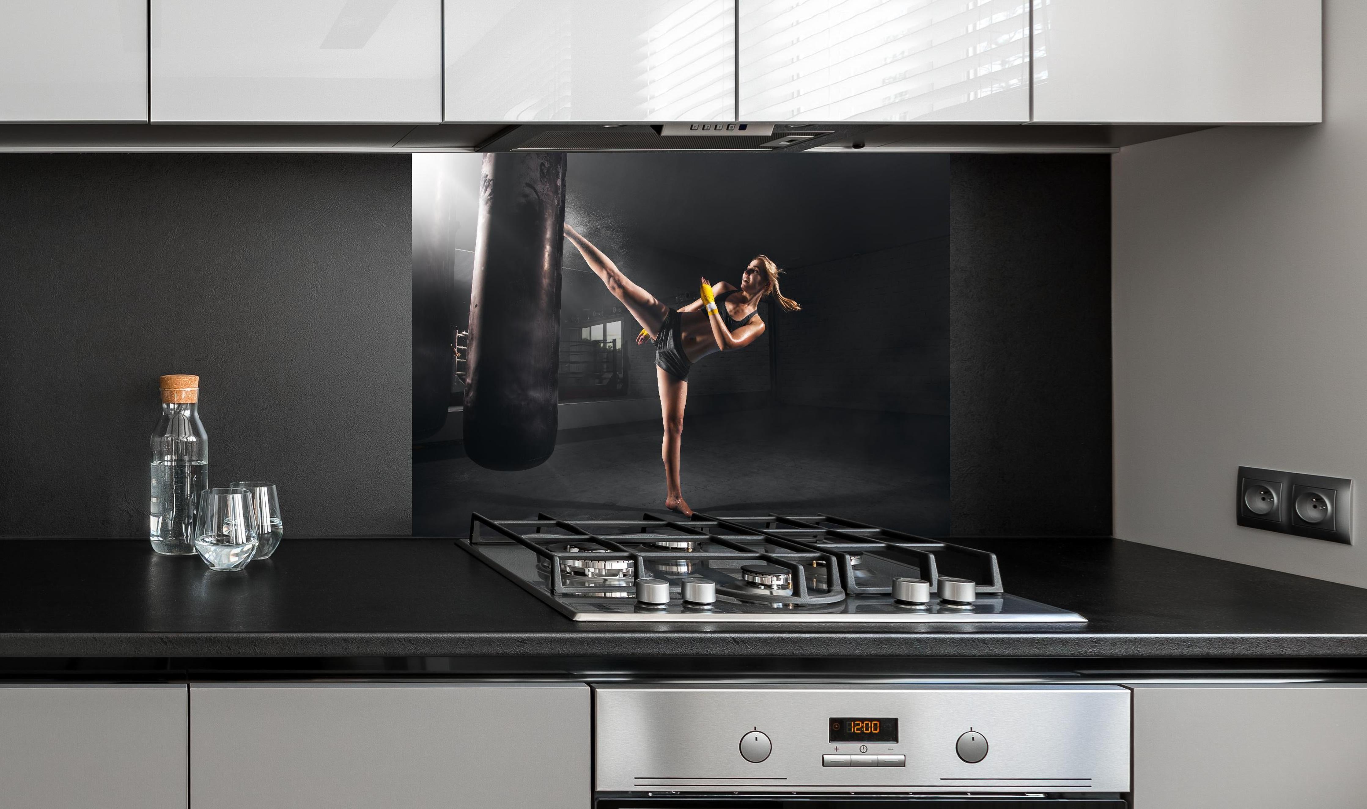 Spritzschutz - Kickboxen Sport hinter einem Cerankochfeld zwischen Holz-Kochutensilien