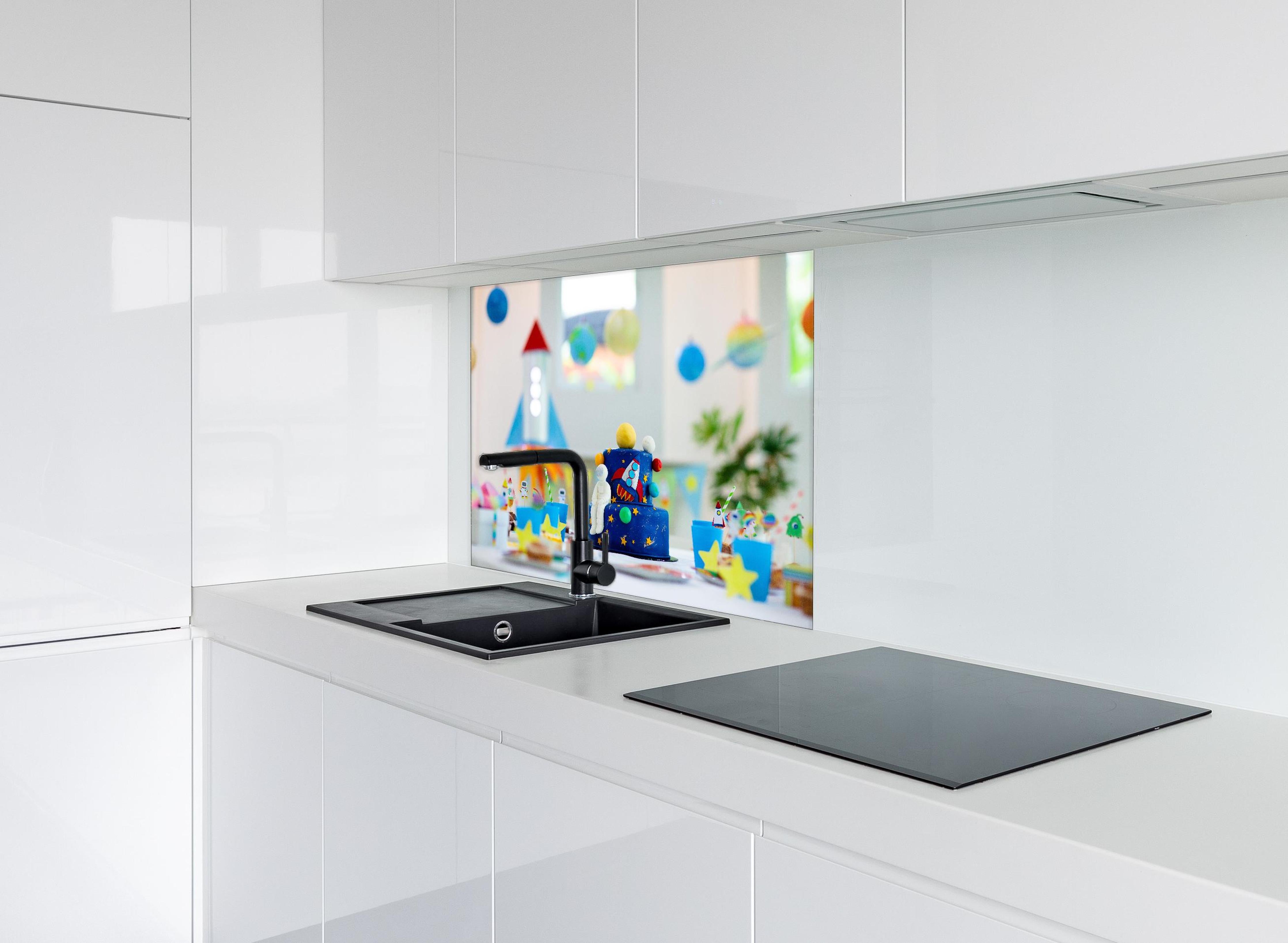 Spritzschutz - Kindergeburtstagsfeier zum Thema Weltraum mit Kuchen. hinter einem Cerankochfeld zwischen Holz-Kochutensilien