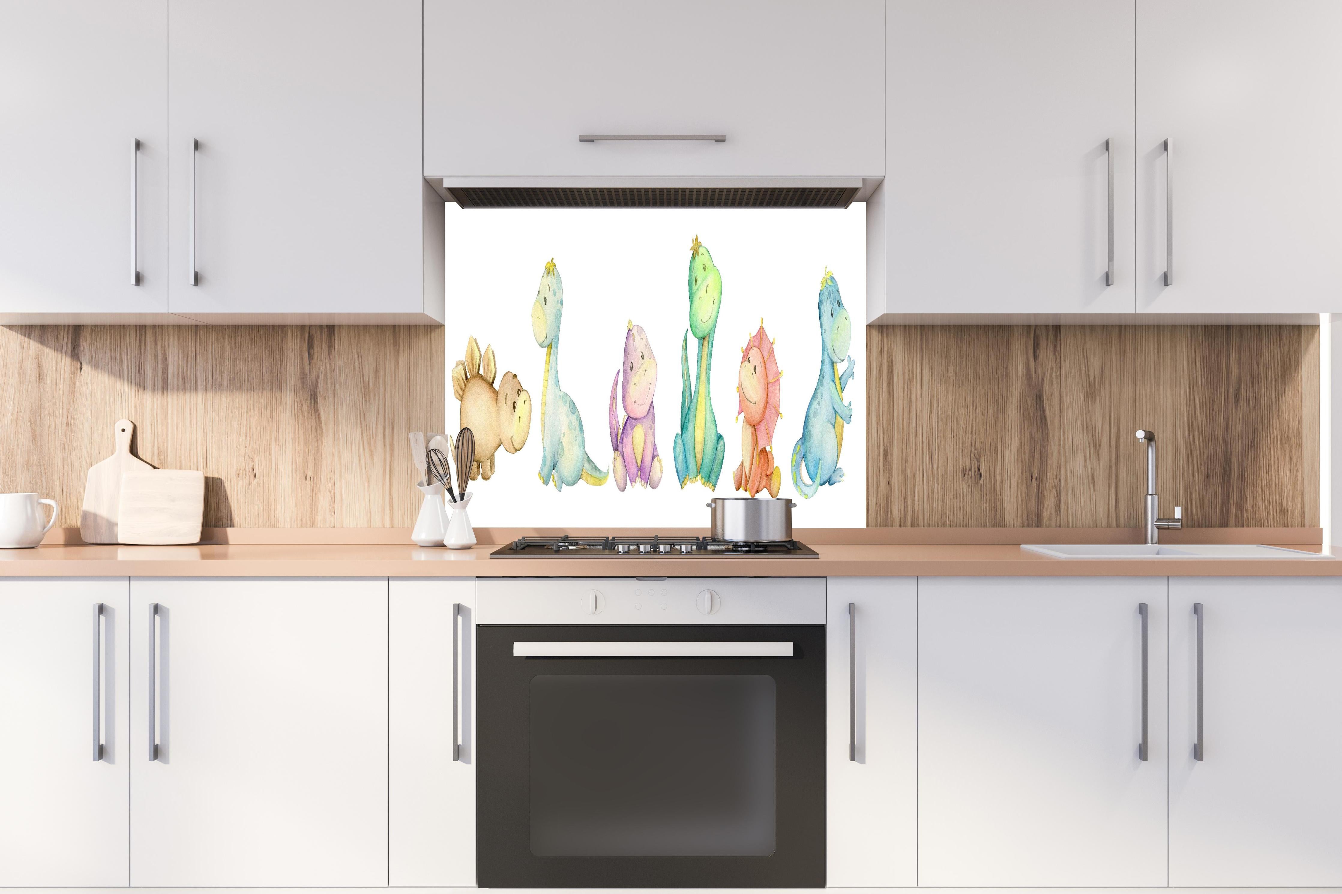 Spritzschutz - Kindliche Dinosaurier hinter einem Cerankochfeld zwischen Holz-Kochutensilien