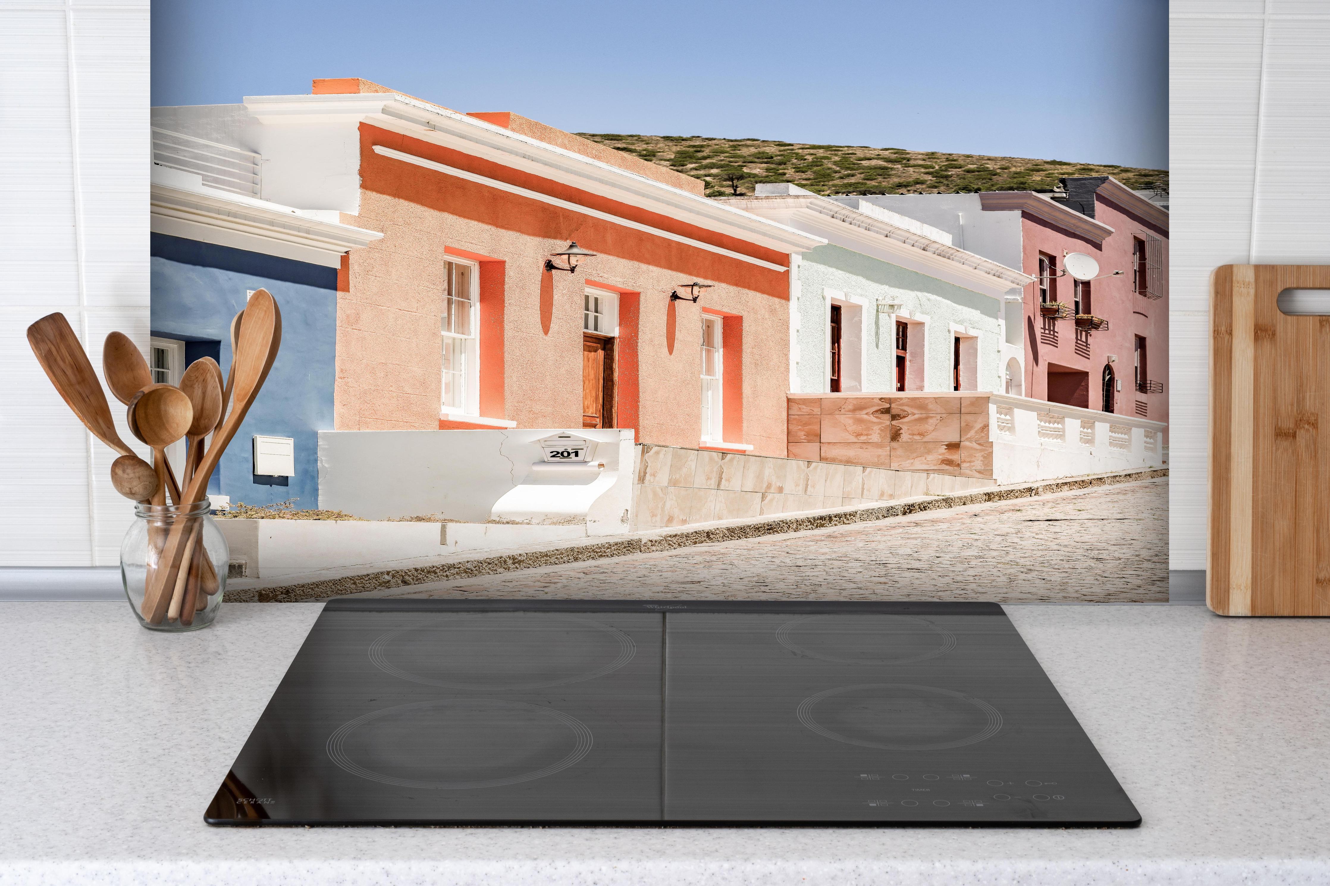 Spritzschutz - Klassische Kap-Holländische Gebäudetür hinter einem Cerankochfeld zwischen Holz-Kochutensilien