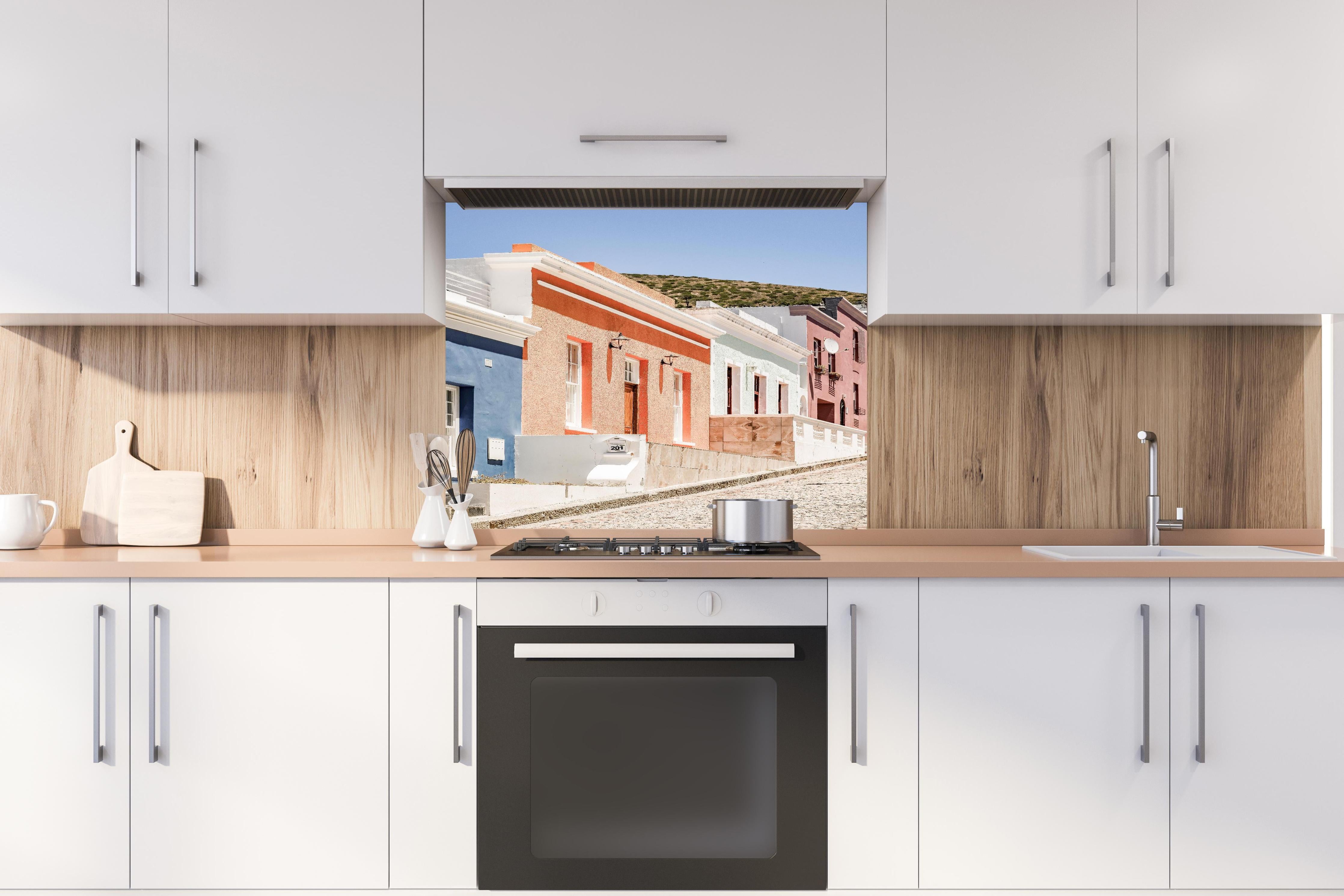 Spritzschutz - Klassische Kap-Holländische Gebäudetür hinter einem Cerankochfeld zwischen Holz-Kochutensilien