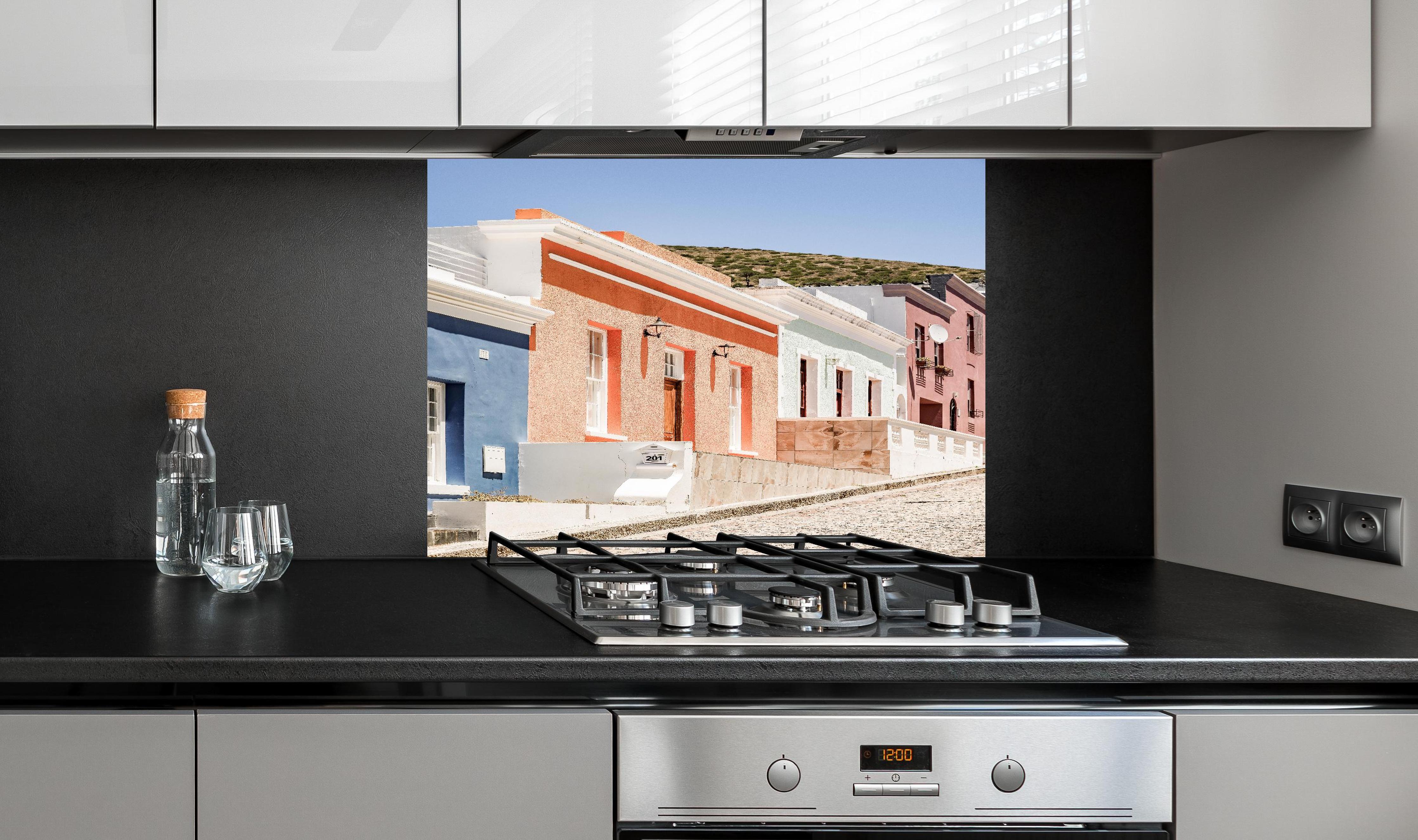 Spritzschutz - Klassische Kap-Holländische Gebäudetür hinter einem Cerankochfeld zwischen Holz-Kochutensilien