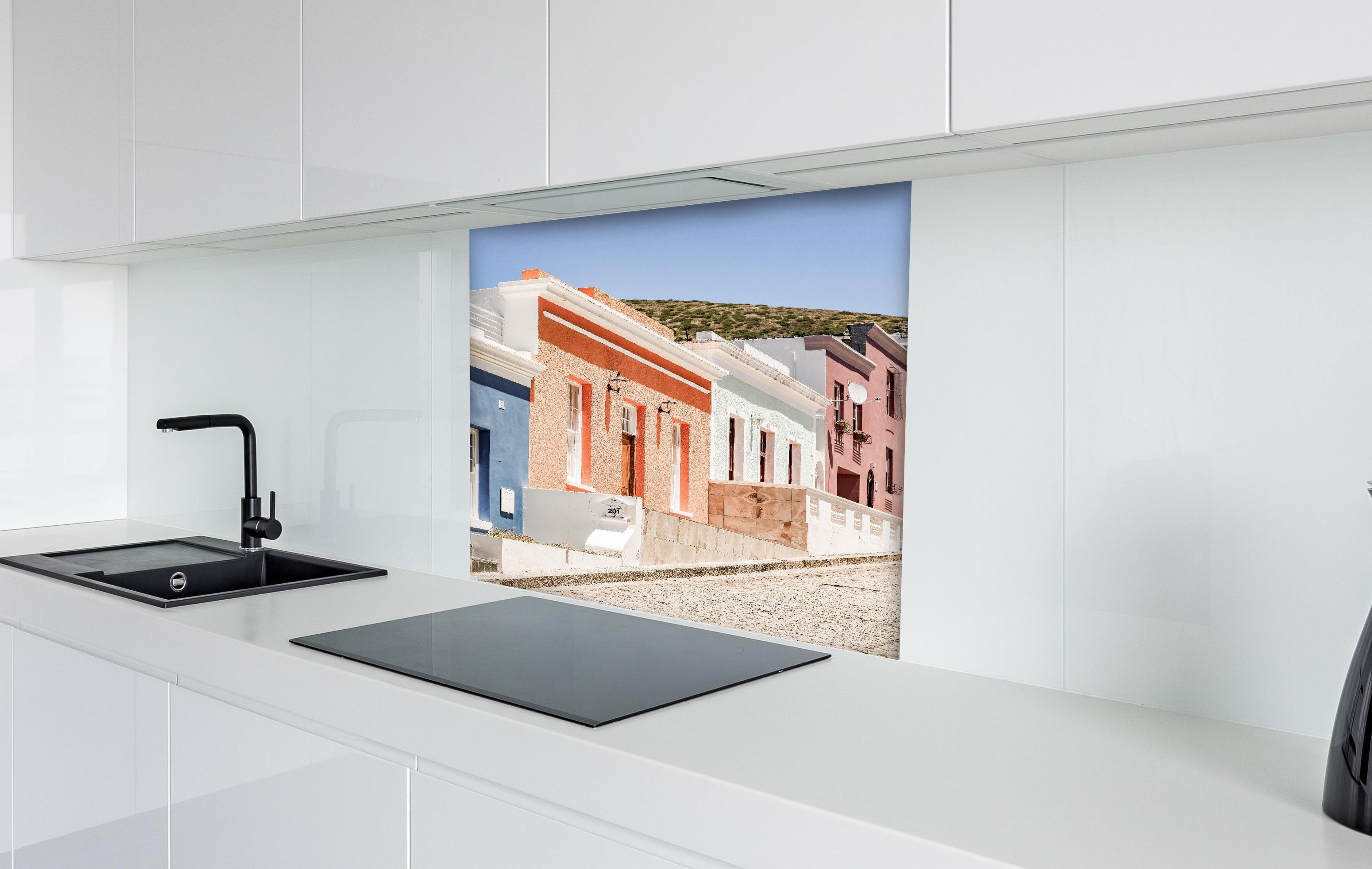 Spritzschutz - Klassische Kap-Holländische Gebäudetür hinter einem Cerankochfeld zwischen Holz-Kochutensilien