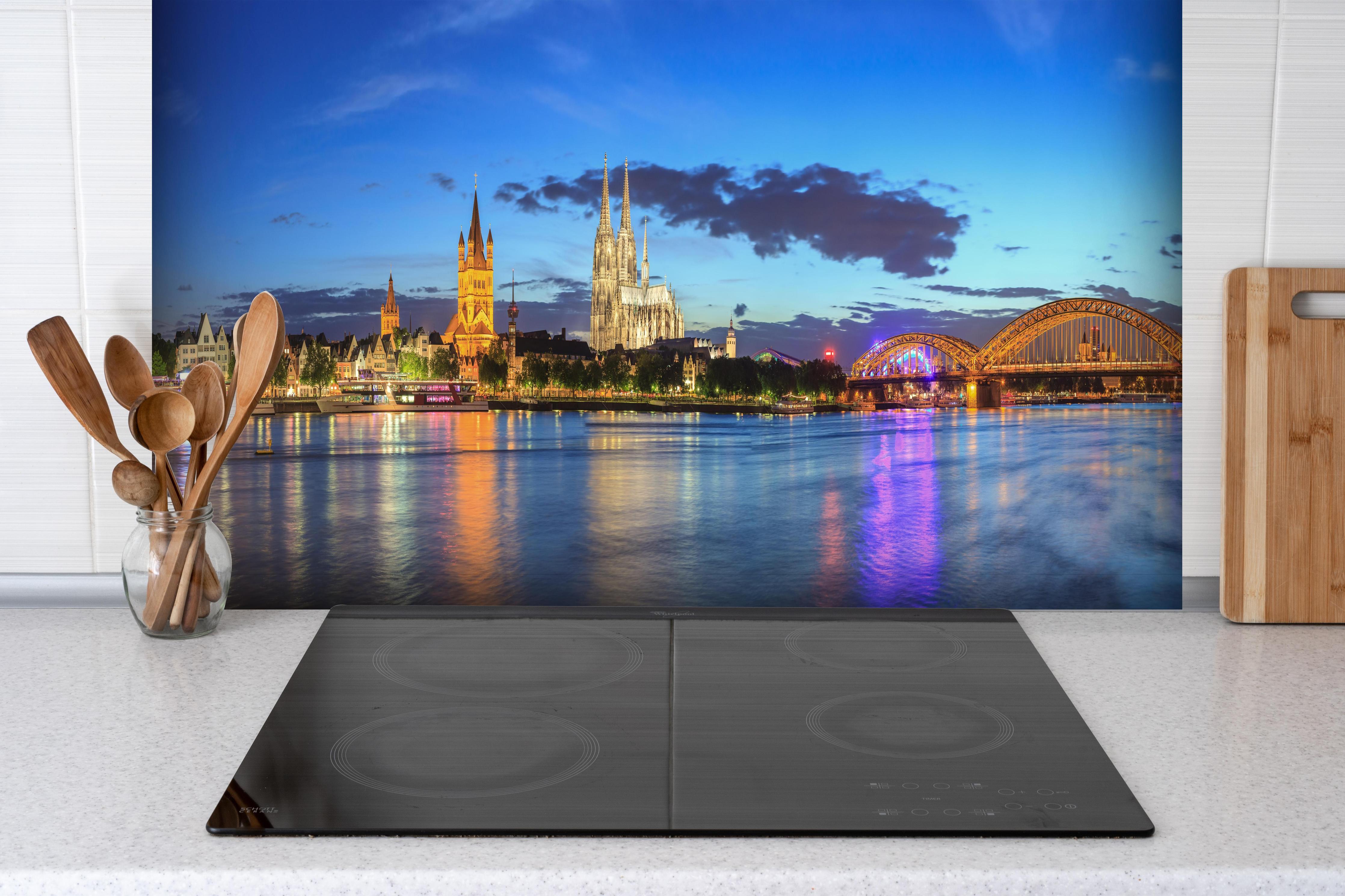 Spritzschutz - Kölner Skyline - Nachts hinter einem Cerankochfeld zwischen Holz-Kochutensilien