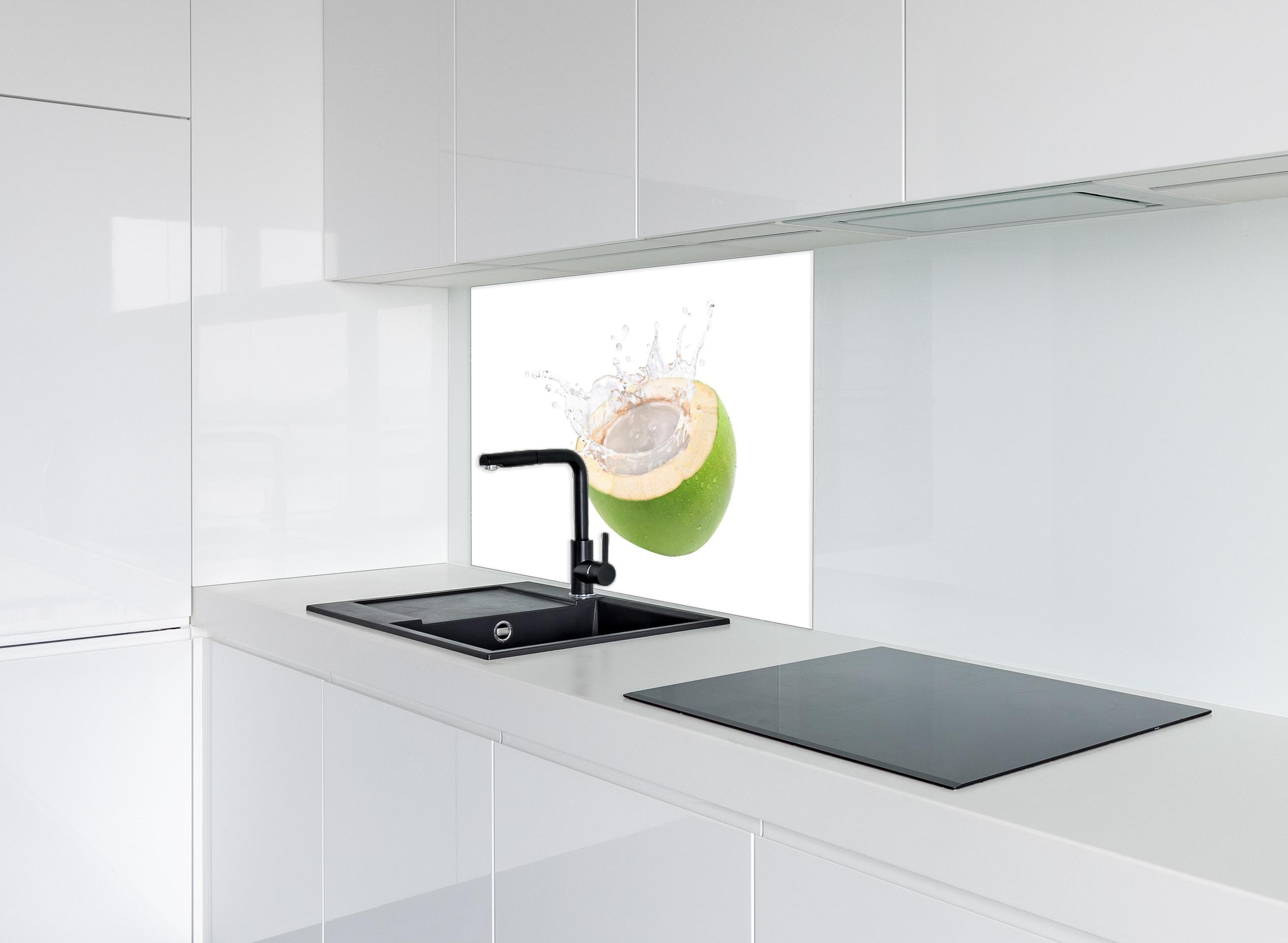 Spritzschutz - Kokosnuss mit Kokosmilch hinter einem Cerankochfeld zwischen Holz-Kochutensilien