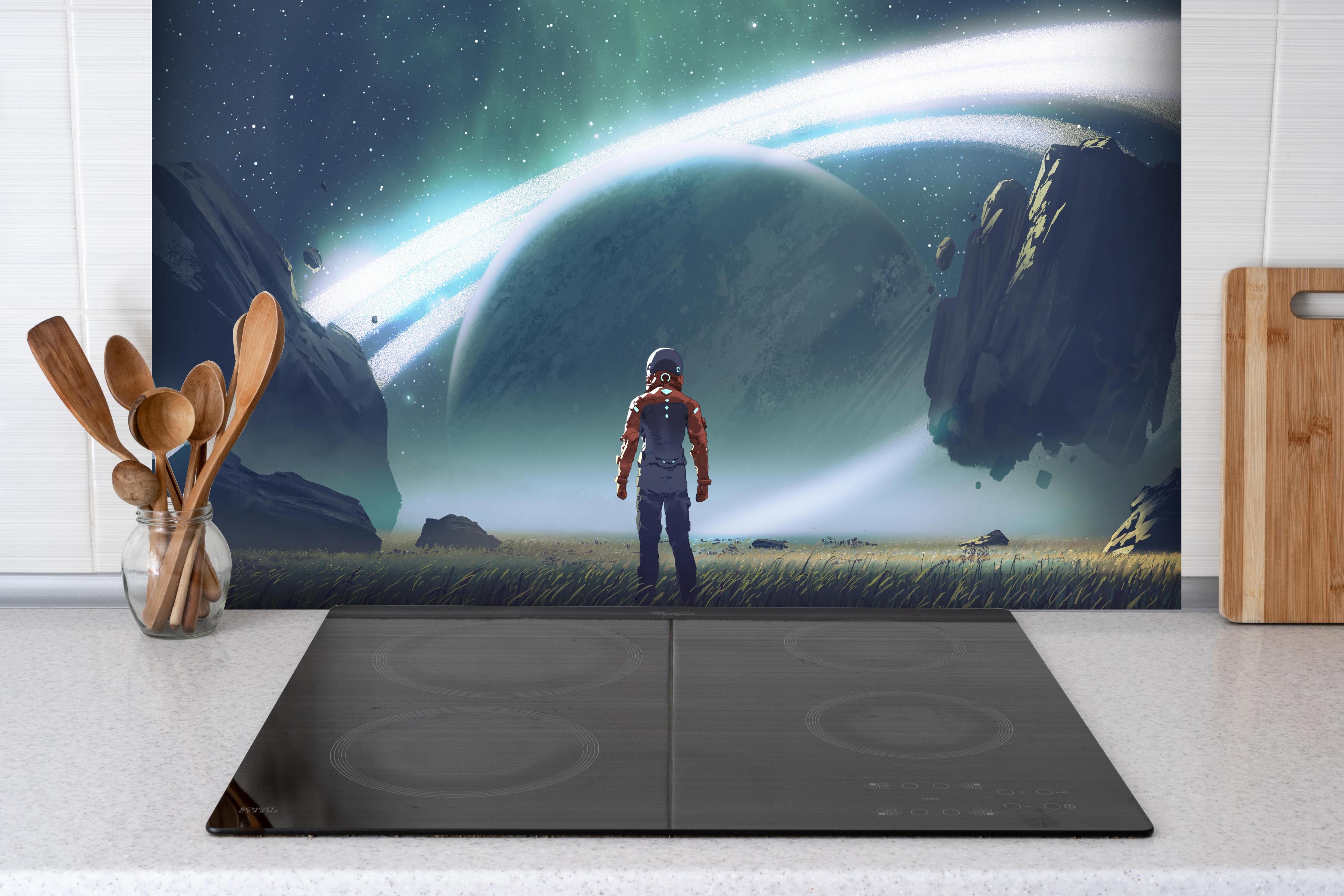 Spritzschutz - Kosmischer Astronaut beim Planetenblick hinter einem Cerankochfeld zwischen Holz-Kochutensilien