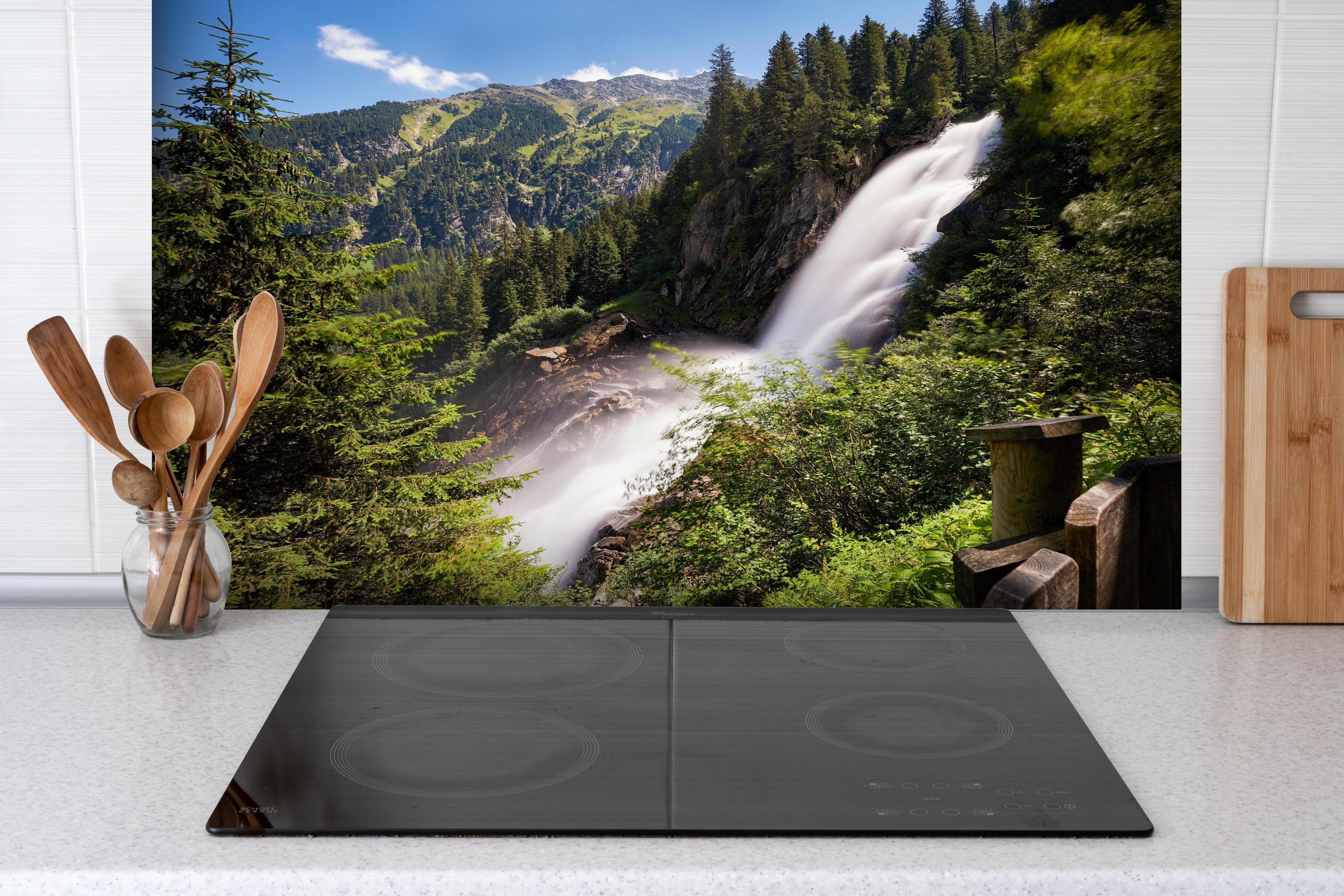 Spritzschutz - Krimmler Wasserfall hinter einem Cerankochfeld zwischen Holz-Kochutensilien