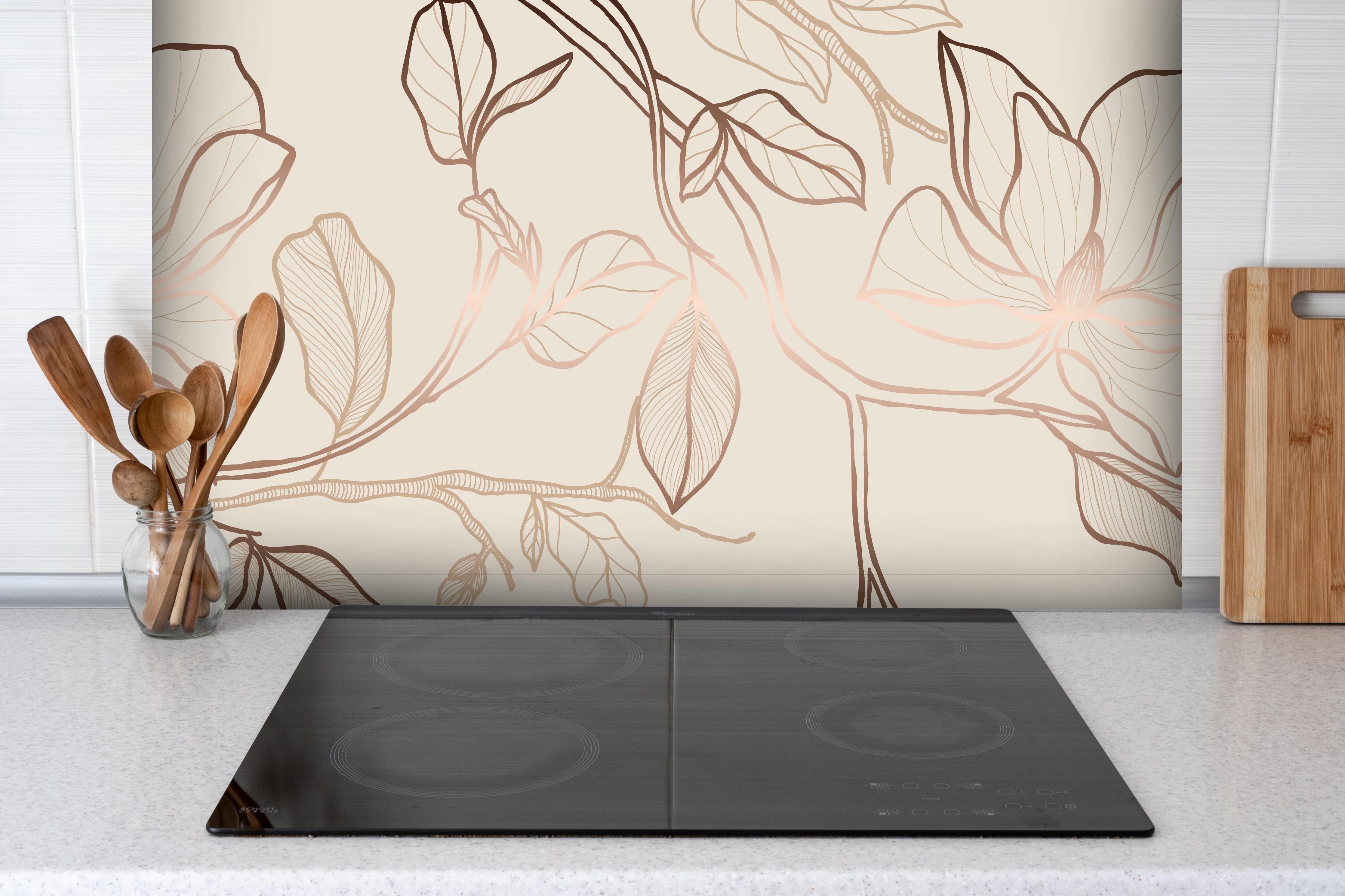 Spritzschutz - Kupferfarbene Blüten hinter einem Cerankochfeld zwischen Holz-Kochutensilien