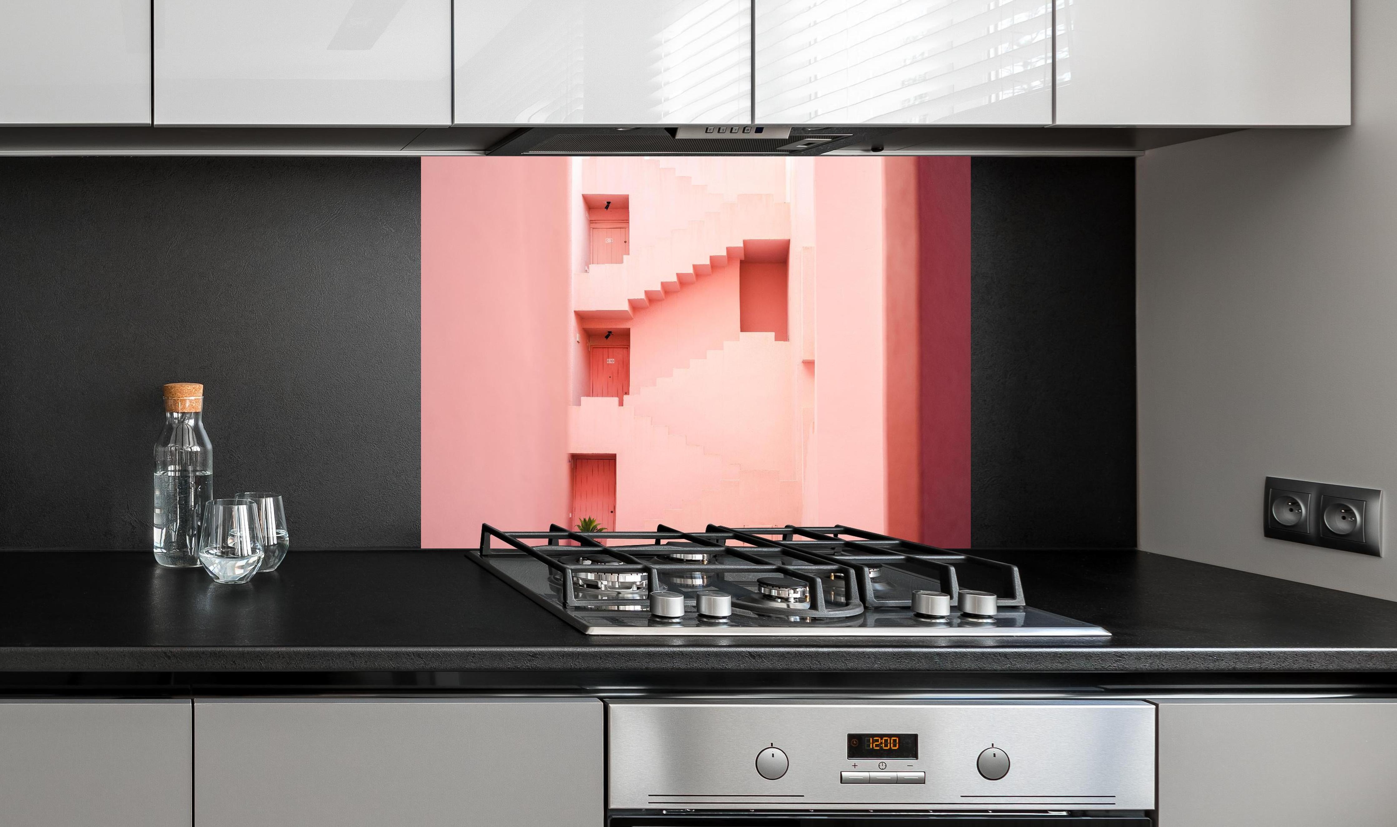 Spritzschutz - La Muralla Roja in Pink, Spanisches Design hinter einem Cerankochfeld zwischen Holz-Kochutensilien