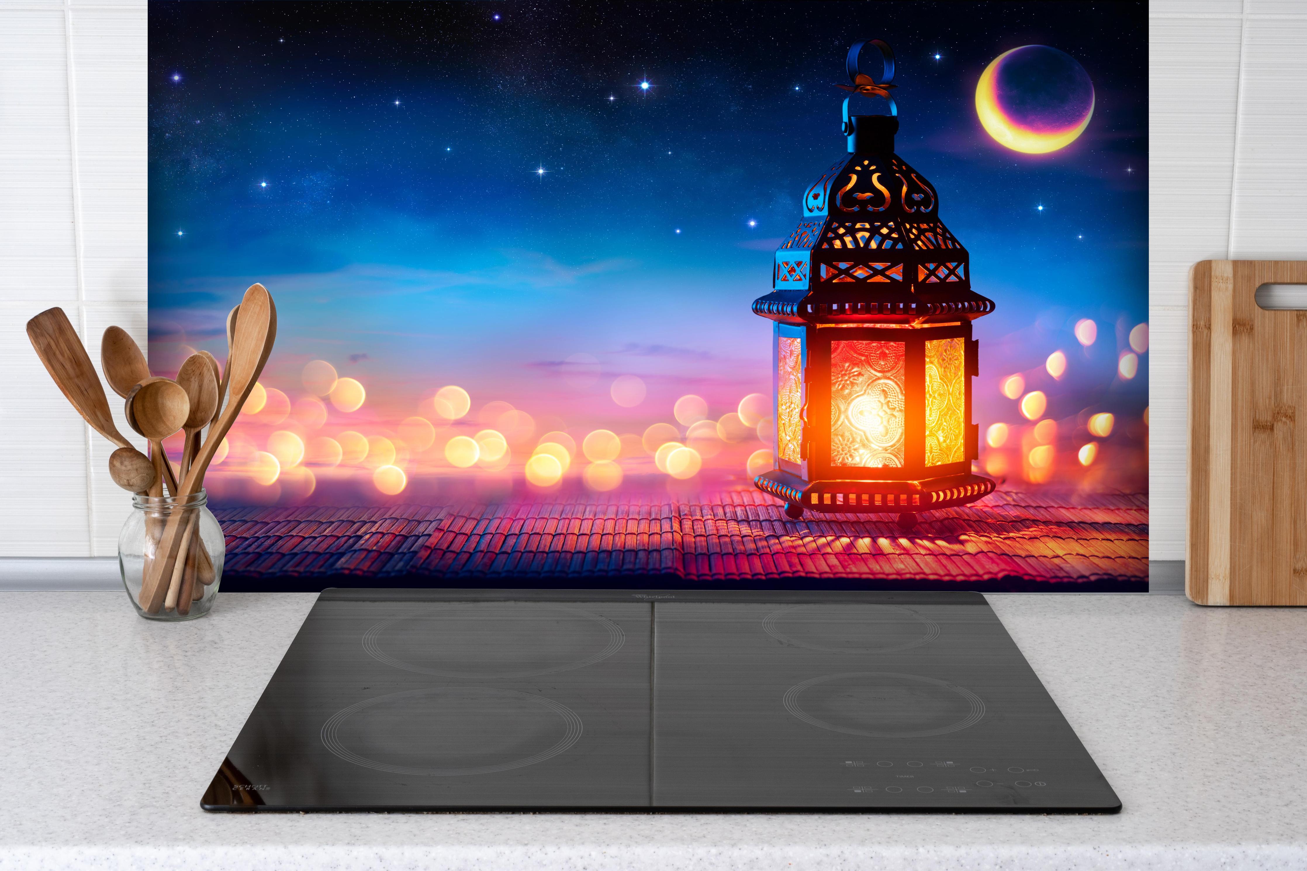 Spritzschutz - Laternenlicht bei Sternenhimmel hinter einem Cerankochfeld zwischen Holz-Kochutensilien