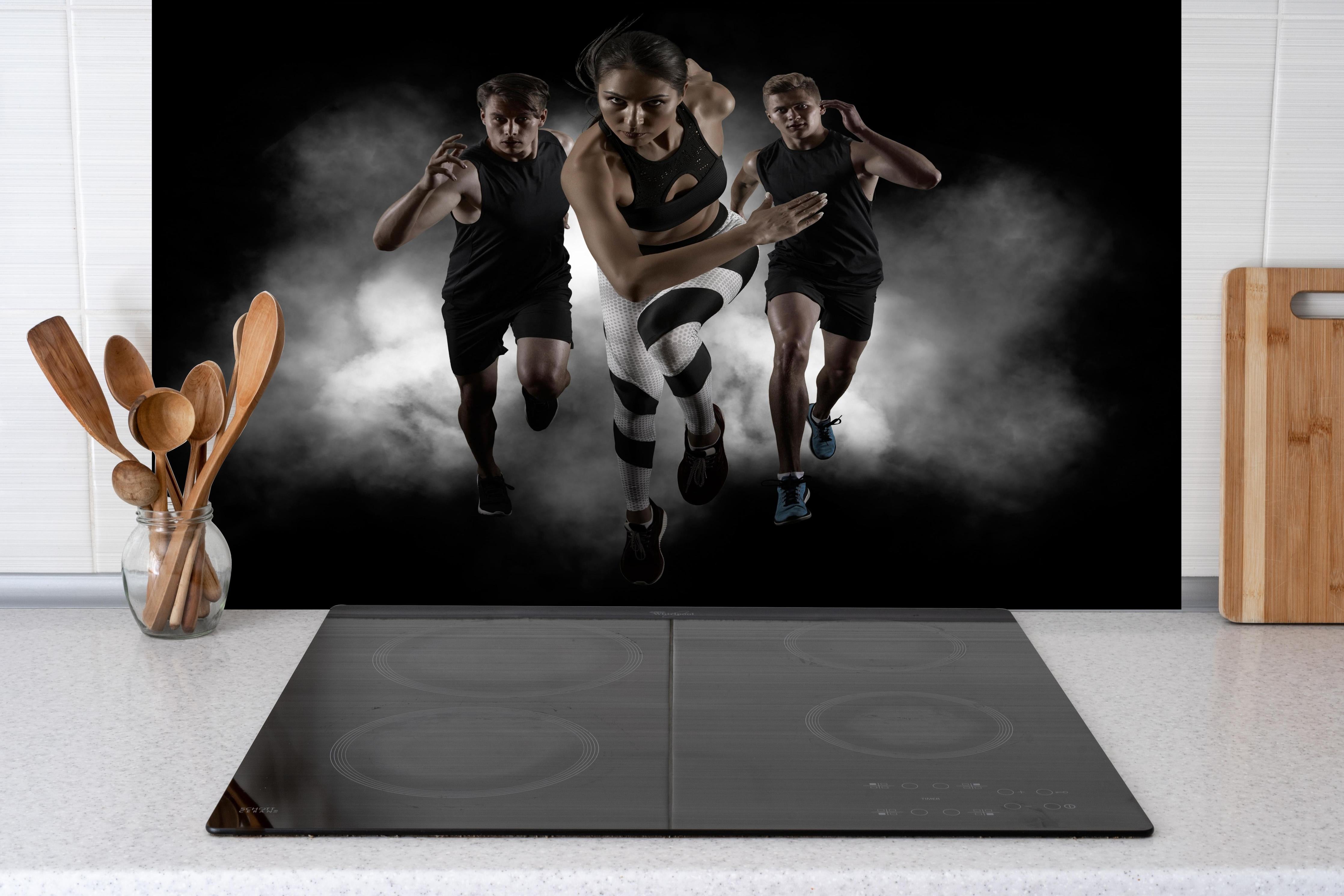 Spritzschutz - Lauf-Dynamik in Schwarz mit Weiß hinter einem Cerankochfeld zwischen Holz-Kochutensilien