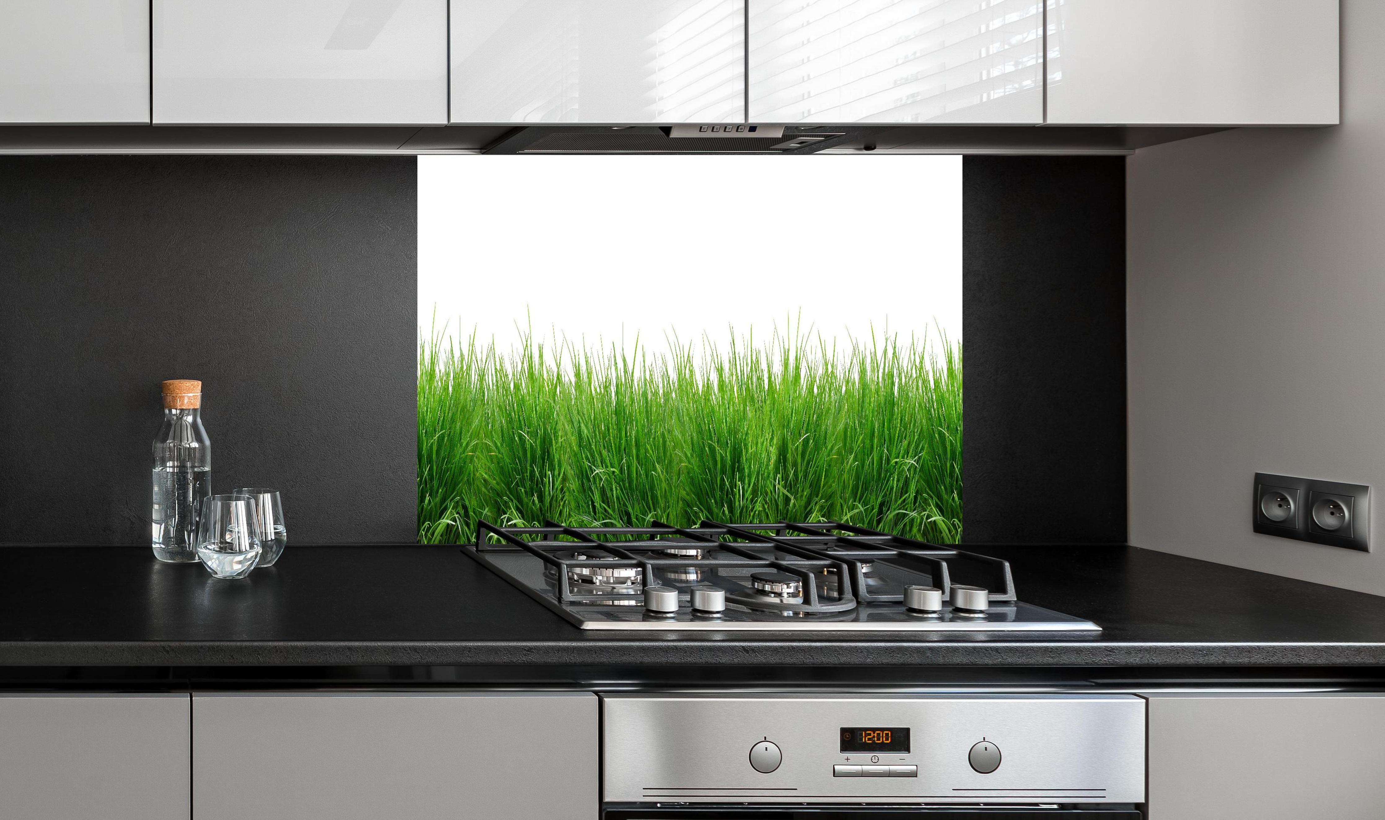 Spritzschutz - Lebendiges Grünes Gras Panoramabild hinter einem Cerankochfeld zwischen Holz-Kochutensilien