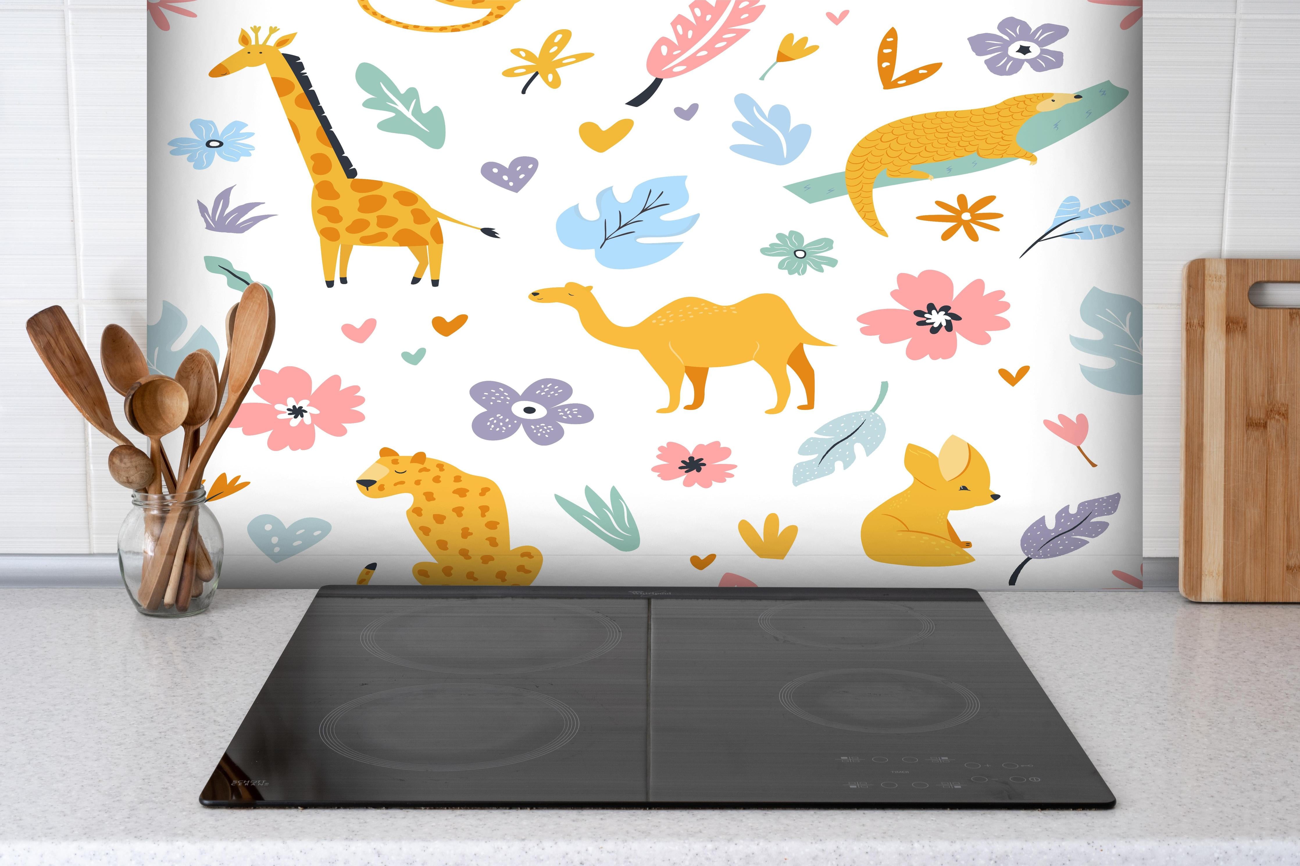 Spritzschutz - Lebhafte Kinderzimmer Tiermotive hinter einem Cerankochfeld zwischen Holz-Kochutensilien