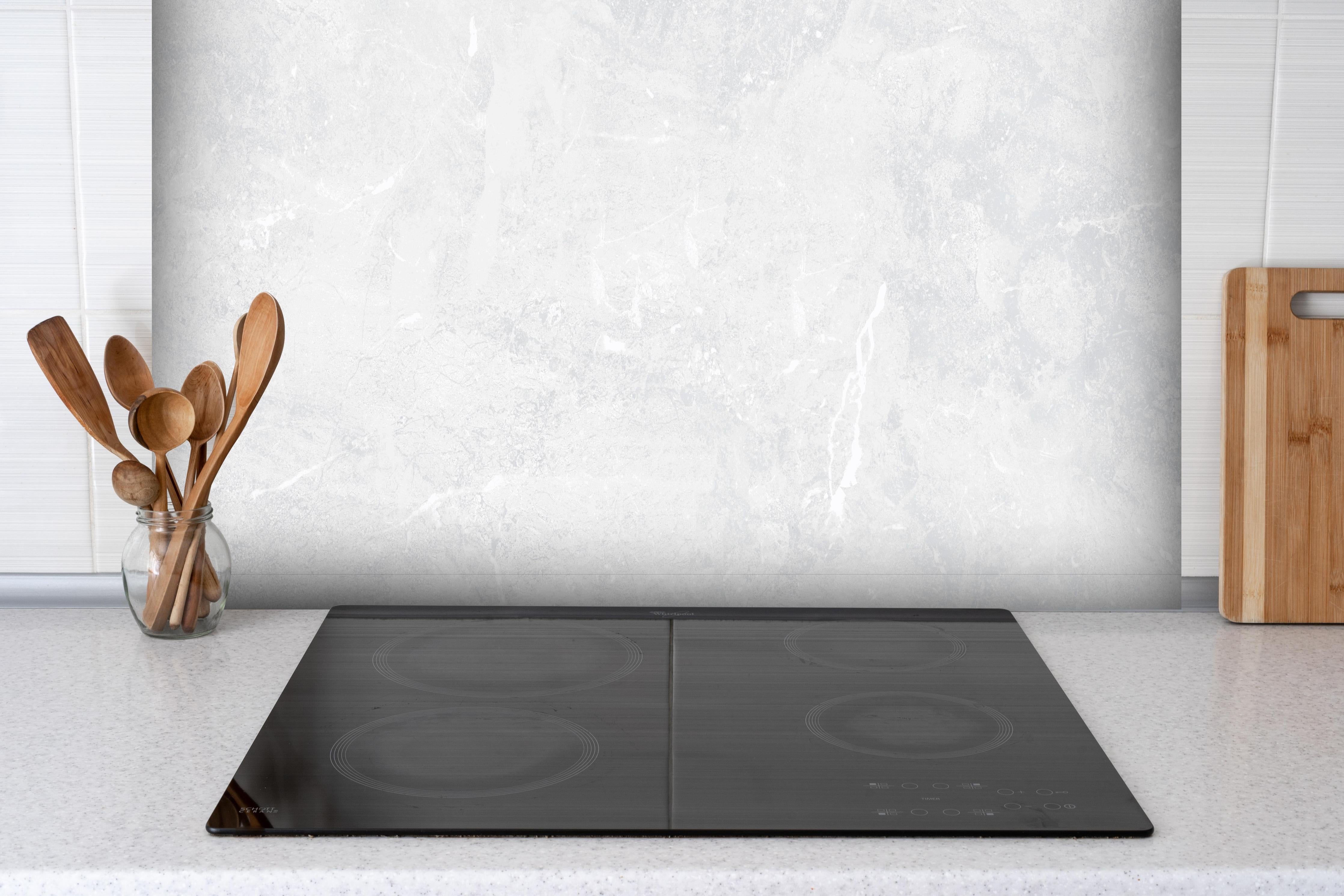 Spritzschutz - Leichtes vintage Muster hinter einem Cerankochfeld zwischen Holz-Kochutensilien