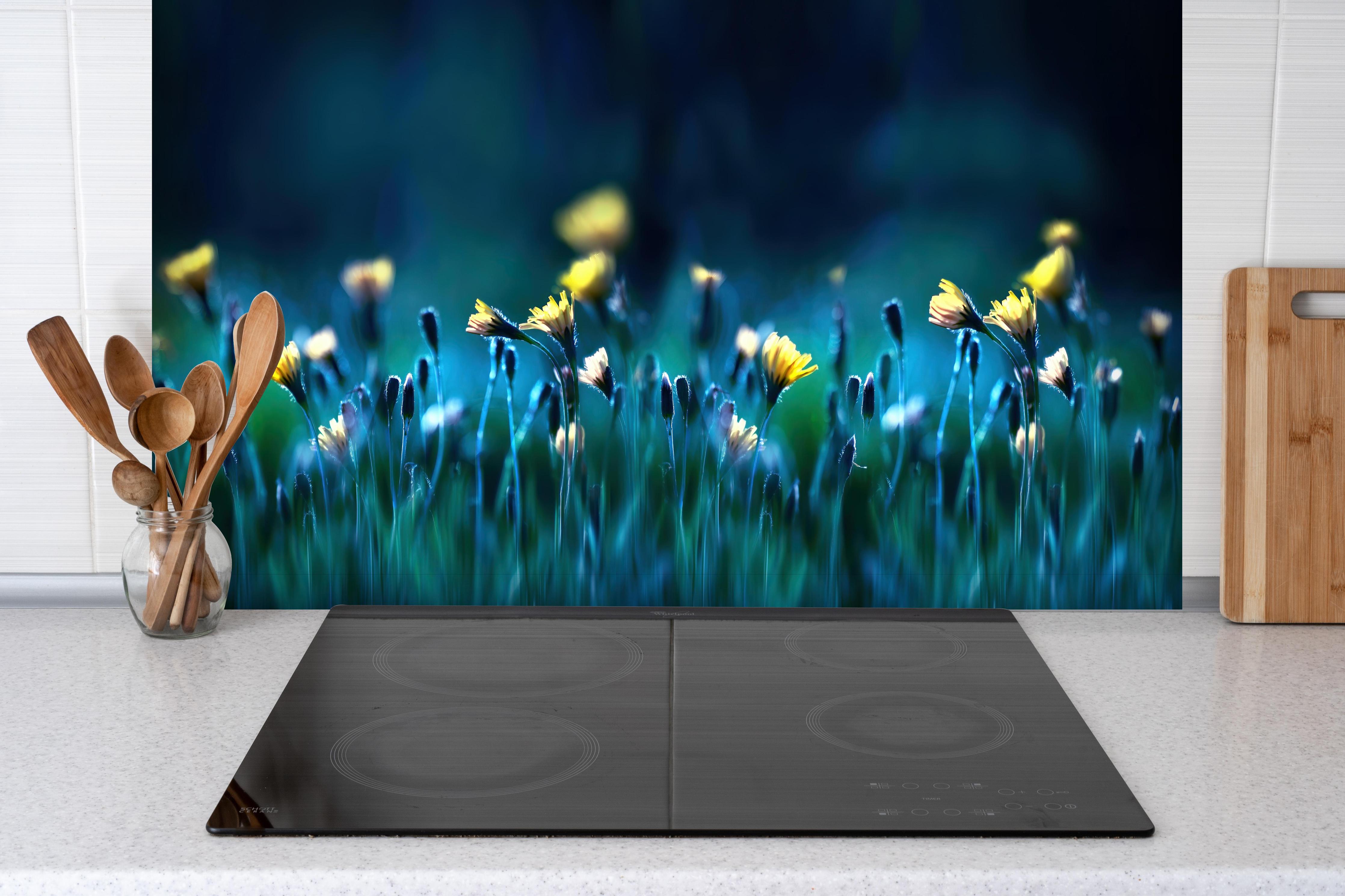 Spritzschutz - Leuchtende Blumen auf dunkelblauer Wiese hinter einem Cerankochfeld zwischen Holz-Kochutensilien