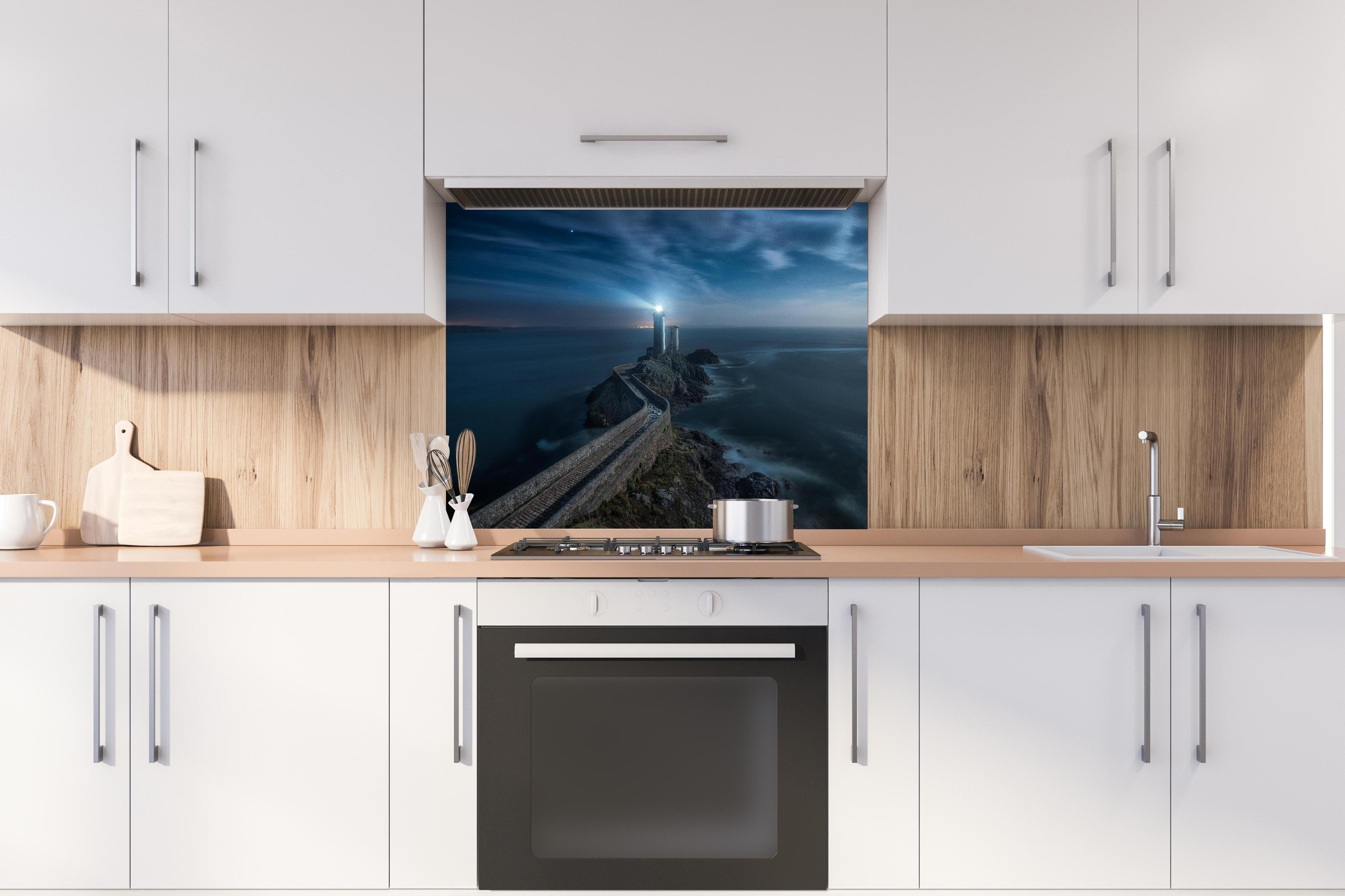 Spritzschutz - Leuchtturm - Nächtlich hinter einem Cerankochfeld zwischen Holz-Kochutensilien