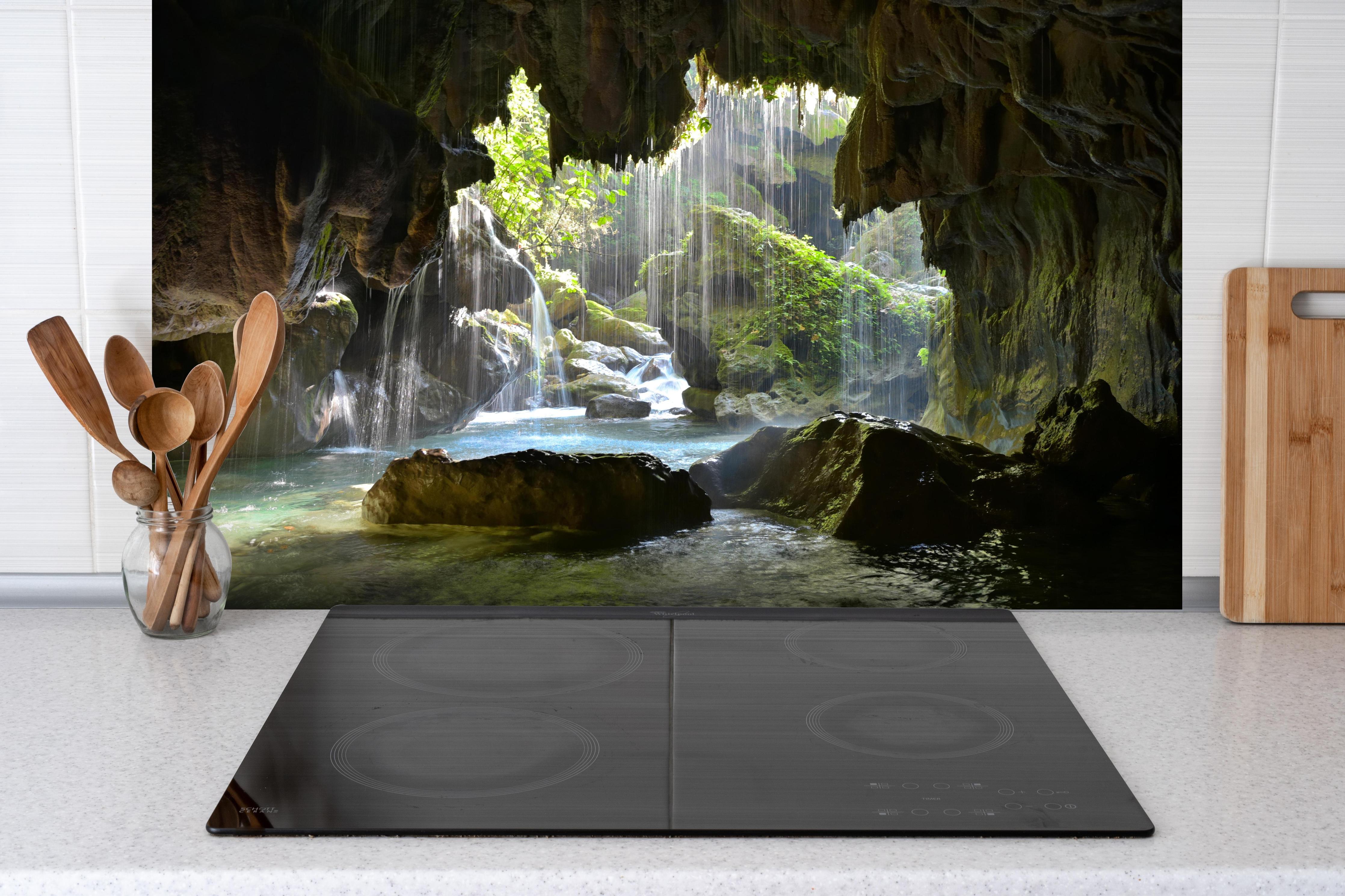 Spritzschutz - Lichtdurchflutete Grüne Höhlenlandschaft hinter einem Cerankochfeld zwischen Holz-Kochutensilien
