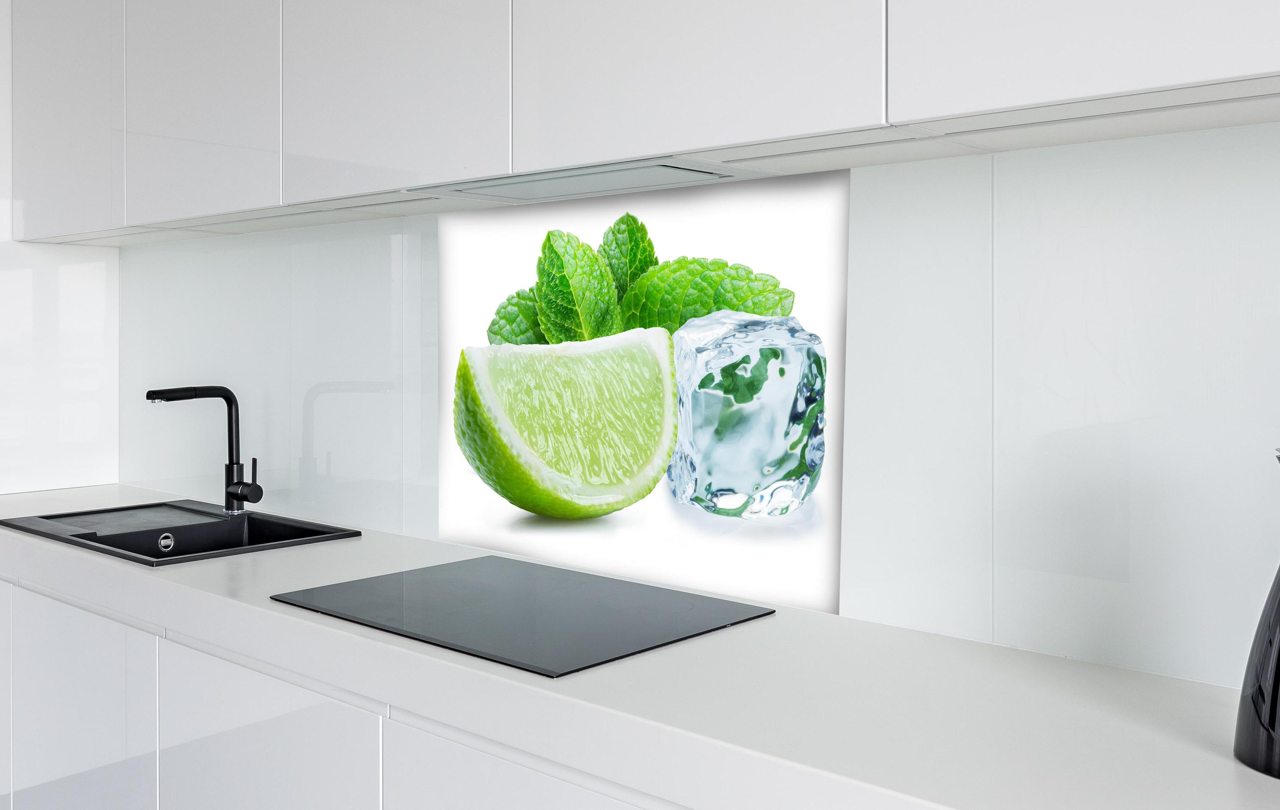Spritzschutz - Limettenscheibe mit Eis und Minze hinter einem Cerankochfeld zwischen Holz-Kochutensilien
