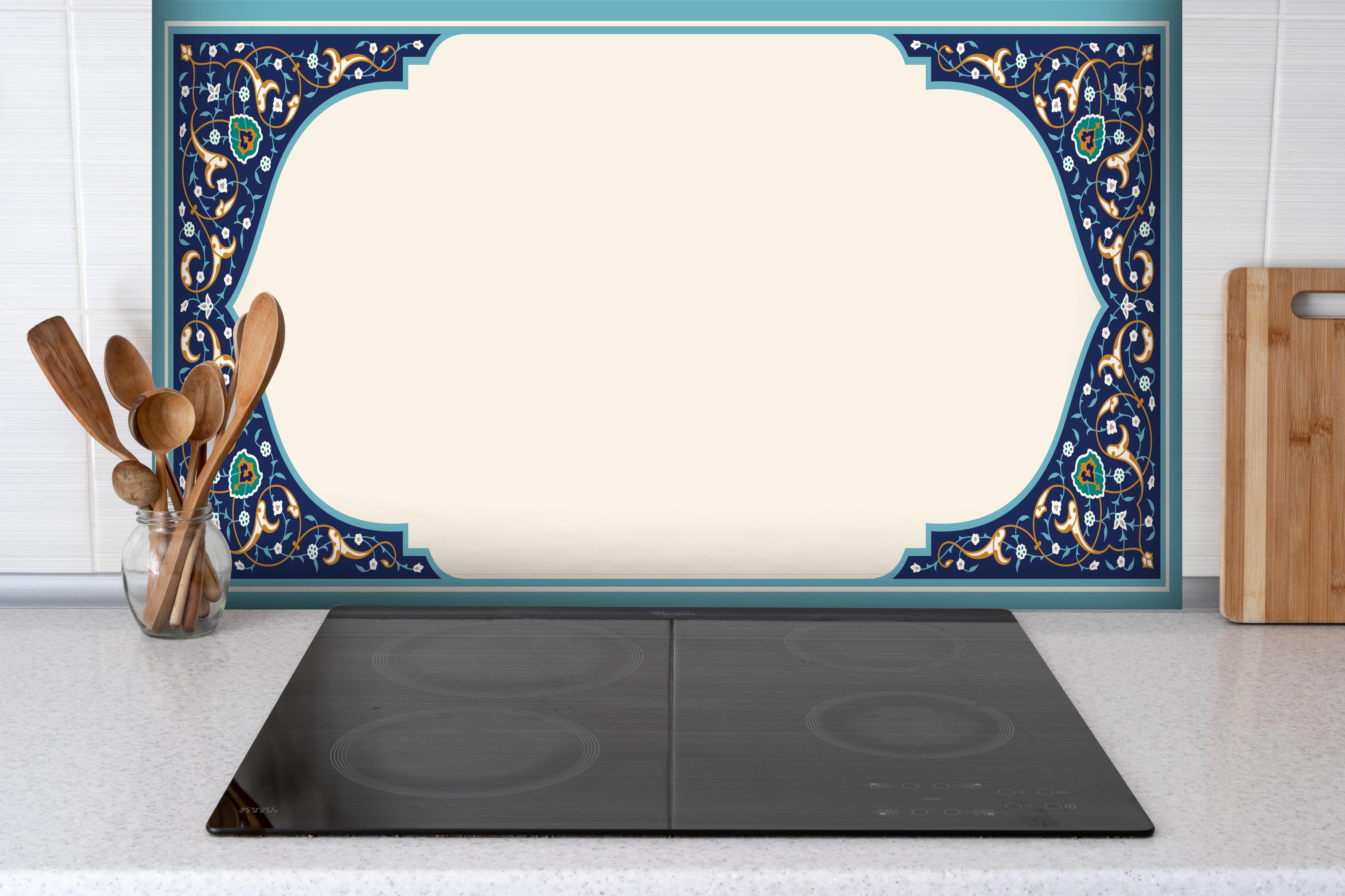 Spritzschutz - Luxuriöser Bilderrahmen mit orientalischem Muster hinter einem Cerankochfeld zwischen Holz-Kochutensilien