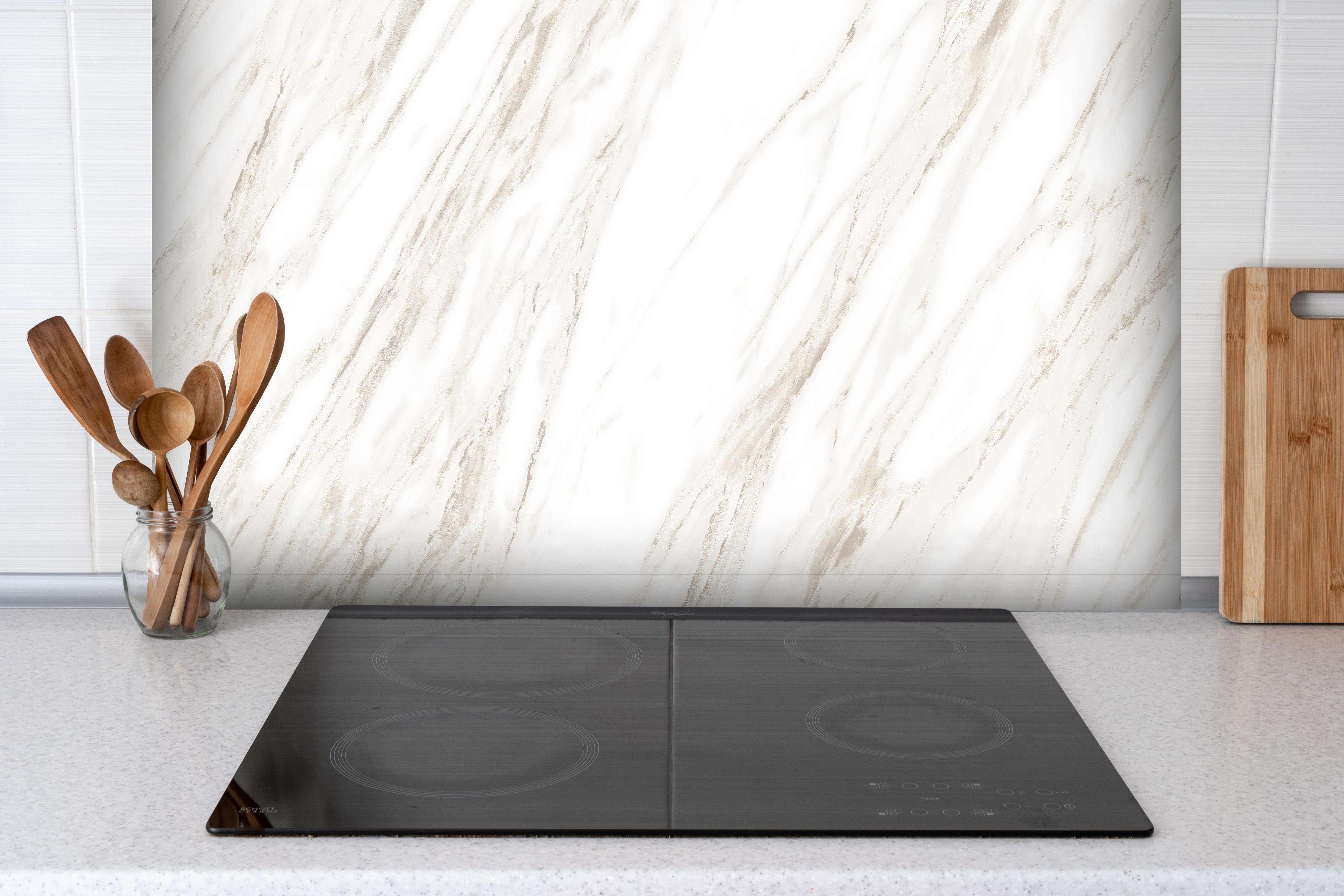 Spritzschutz - Luxuriöses Marmor Design hinter einem Cerankochfeld zwischen Holz-Kochutensilien