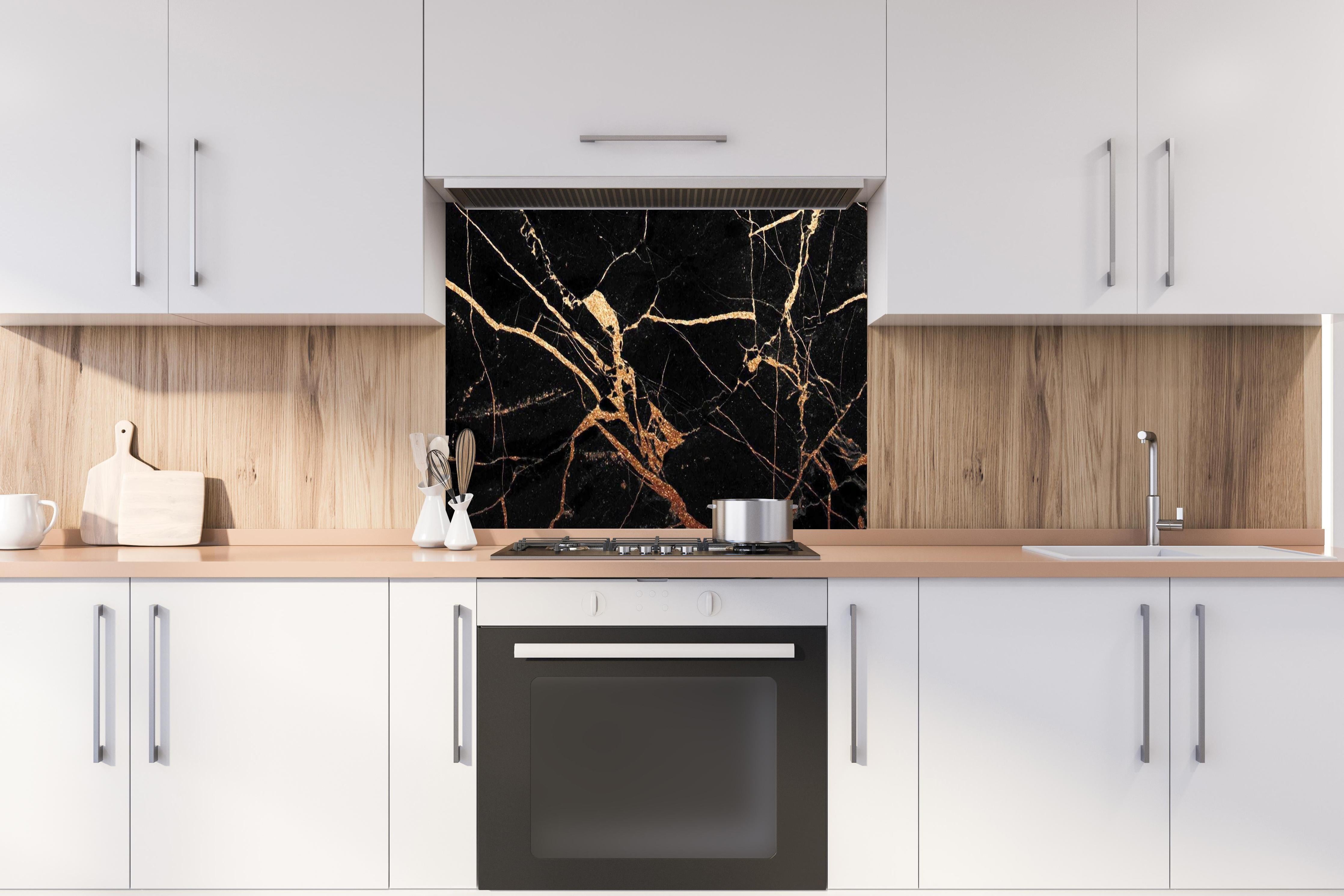 Spritzschutz - Luxus Goldene Ader Marmorstruktur Schwarz hinter einem Cerankochfeld zwischen Holz-Kochutensilien