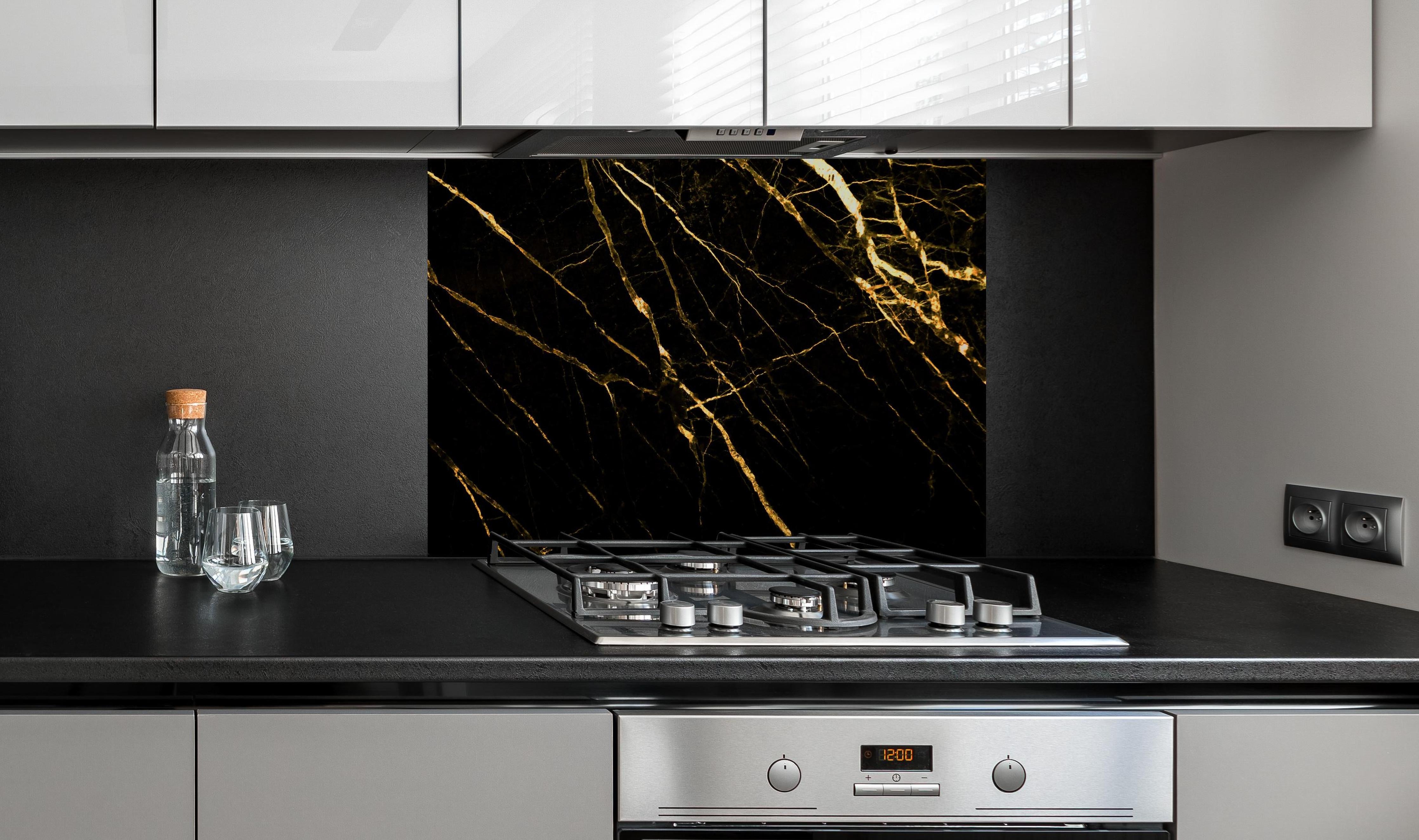 Spritzschutz - Luxus Goldmarmortextur hinter einem Cerankochfeld zwischen Holz-Kochutensilien