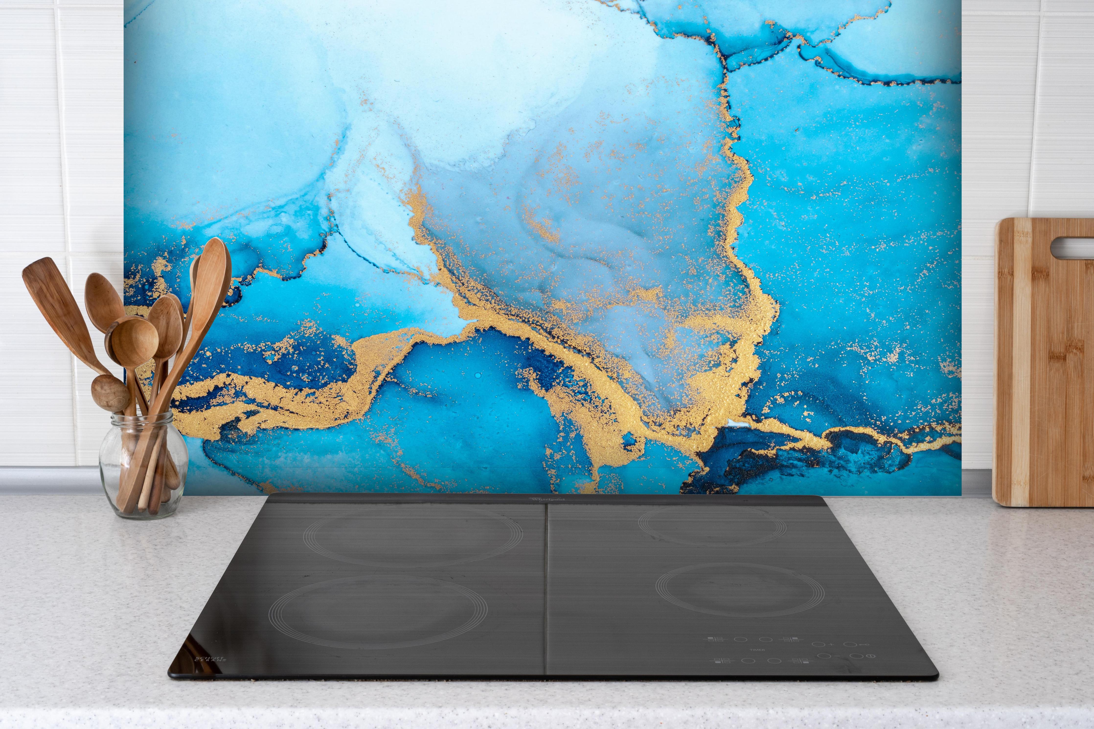 Spritzschutz - Luxus blau mit goldenem Stich - Tintenmalerei hinter einem Cerankochfeld zwischen Holz-Kochutensilien