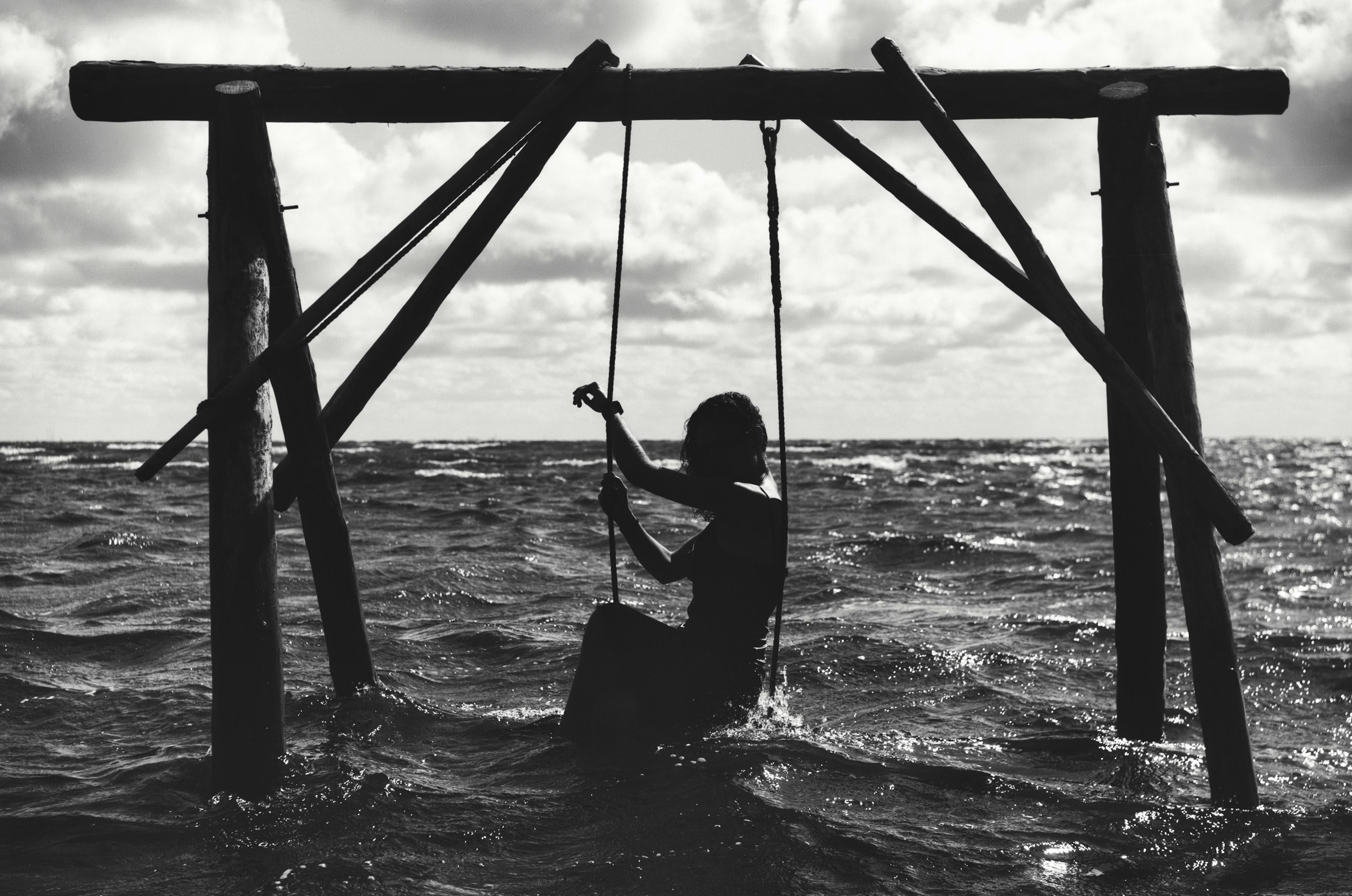 Spritzschutz-Mädchen auf Schaukel im Wasser