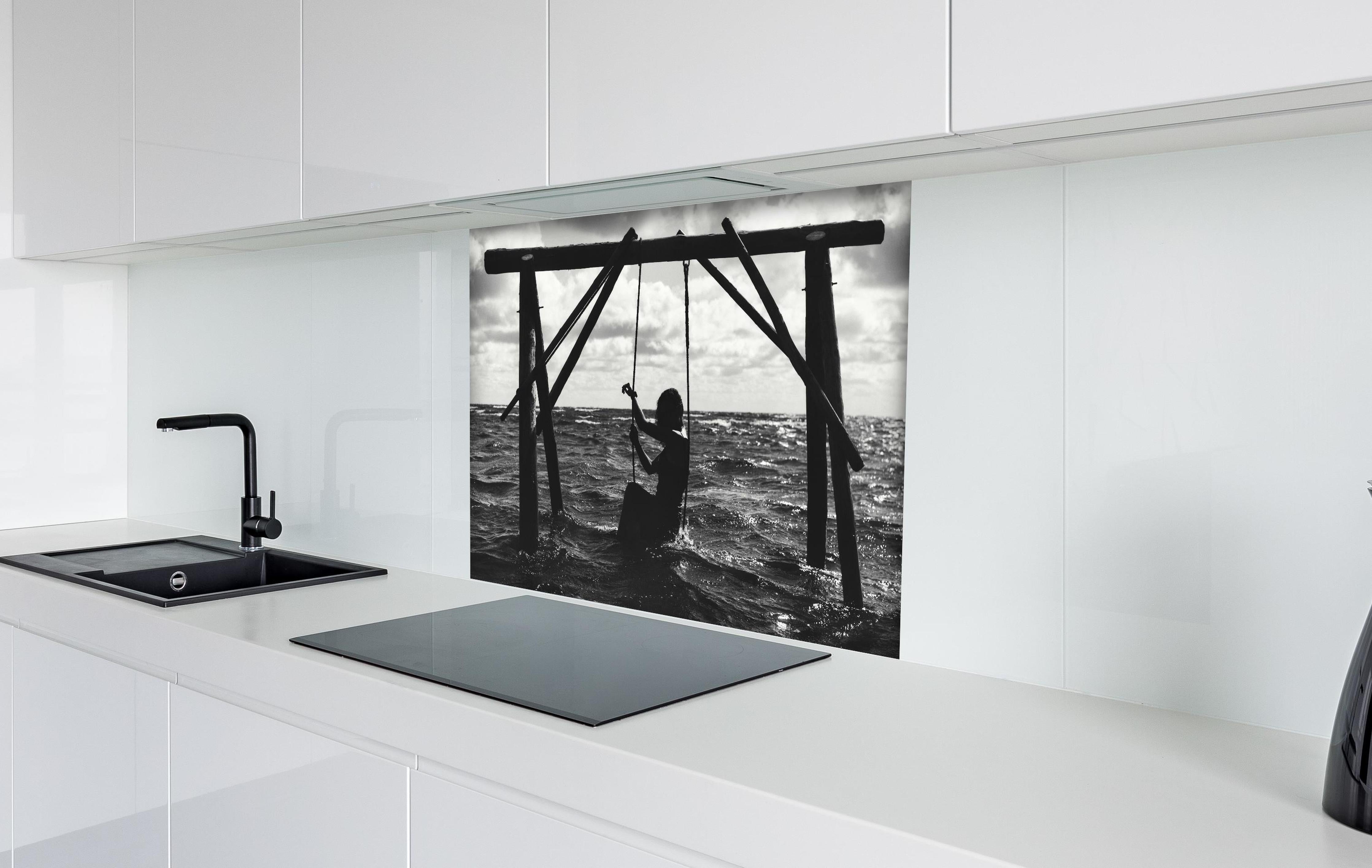 Spritzschutz - Mädchen auf Schaukel im Wasser hinter einem Cerankochfeld zwischen Holz-Kochutensilien