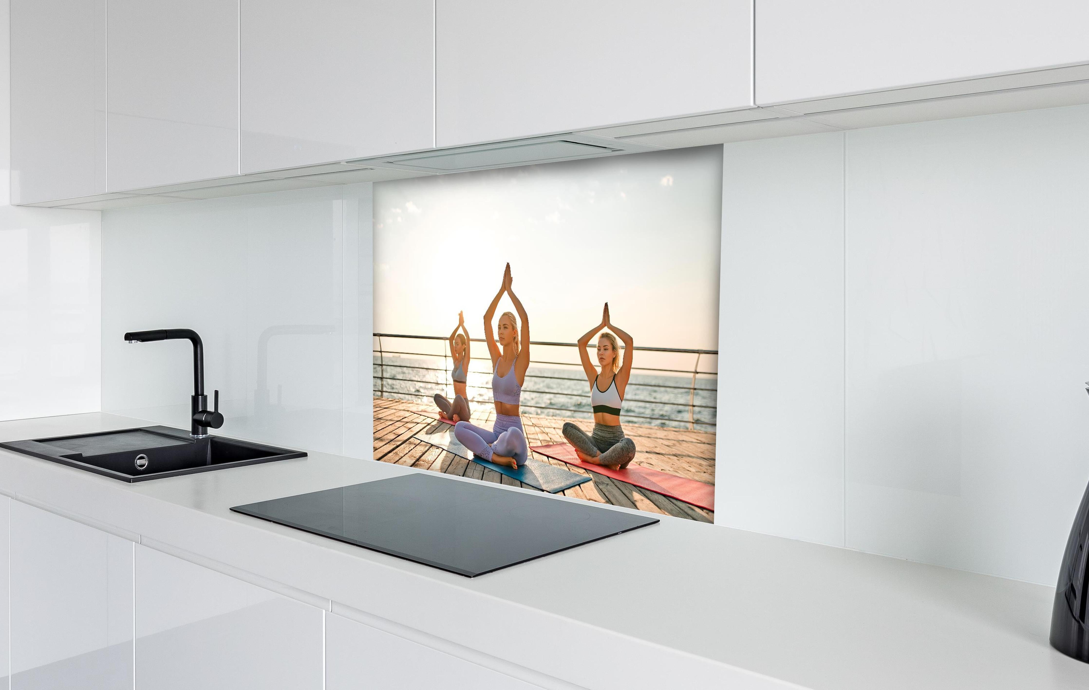 Spritzschutz - Mädchen beim Yoga am Morgen hinter einem Cerankochfeld zwischen Holz-Kochutensilien