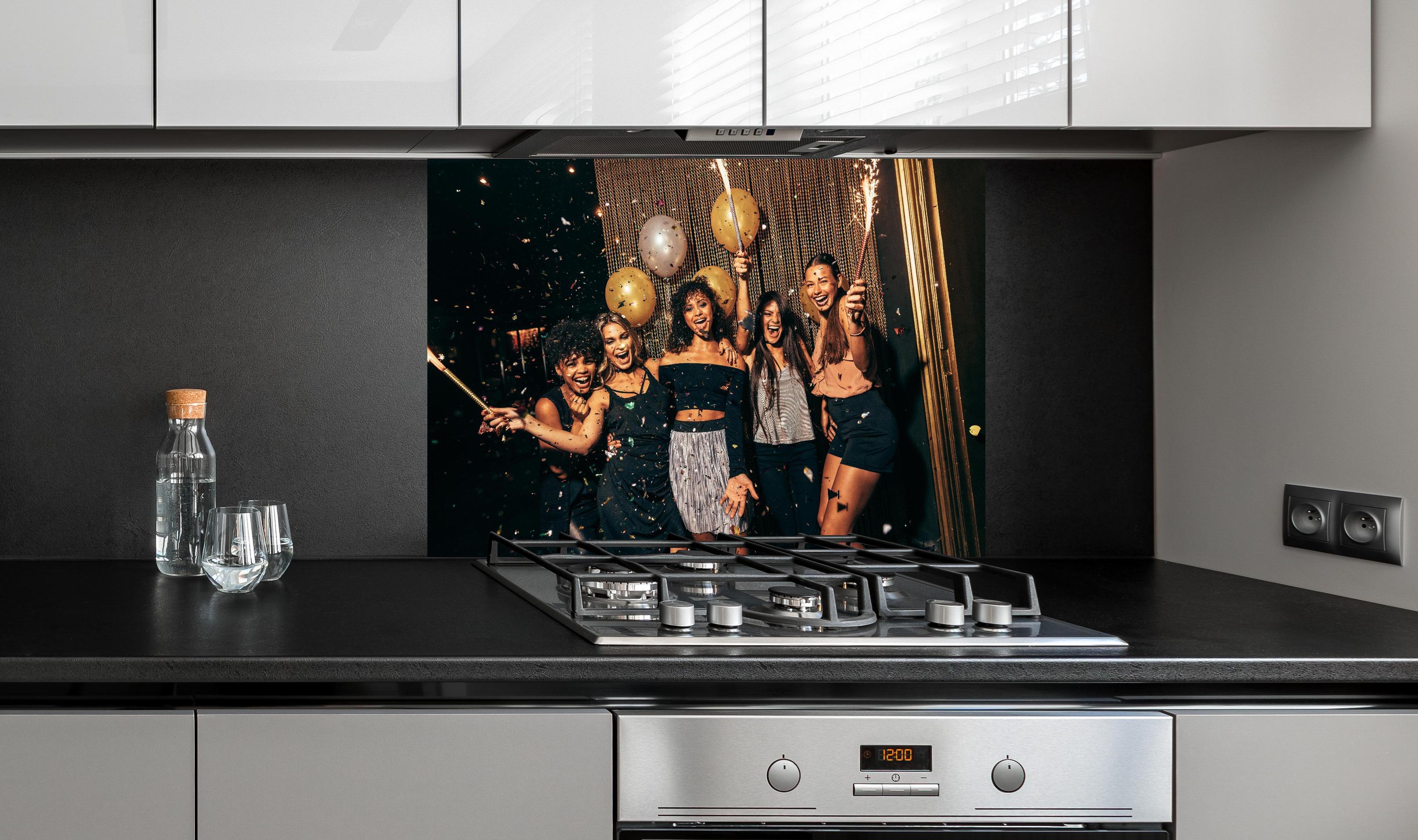 Spritzschutz - Mädchen im Nachtclub haben eine tolle Zeit hinter einem Cerankochfeld zwischen Holz-Kochutensilien