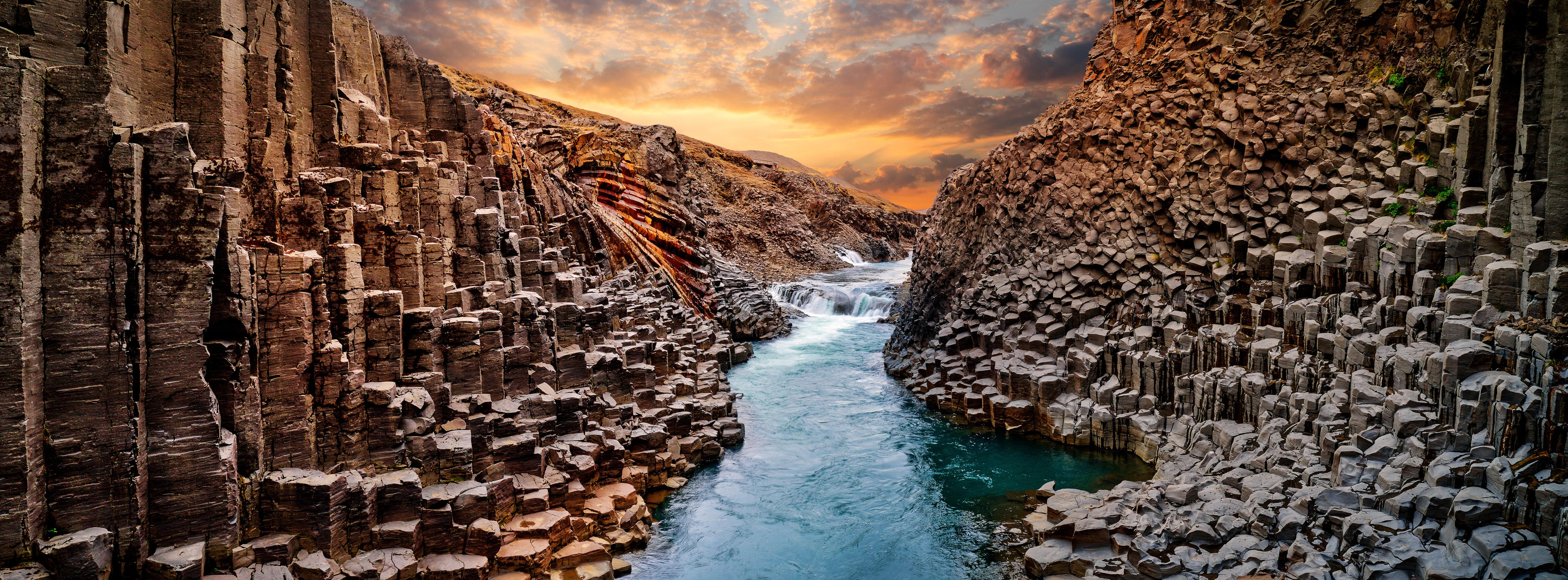 Spritzschutz-Majestätische Basalt-Schlucht Island Sonnenuntergang
