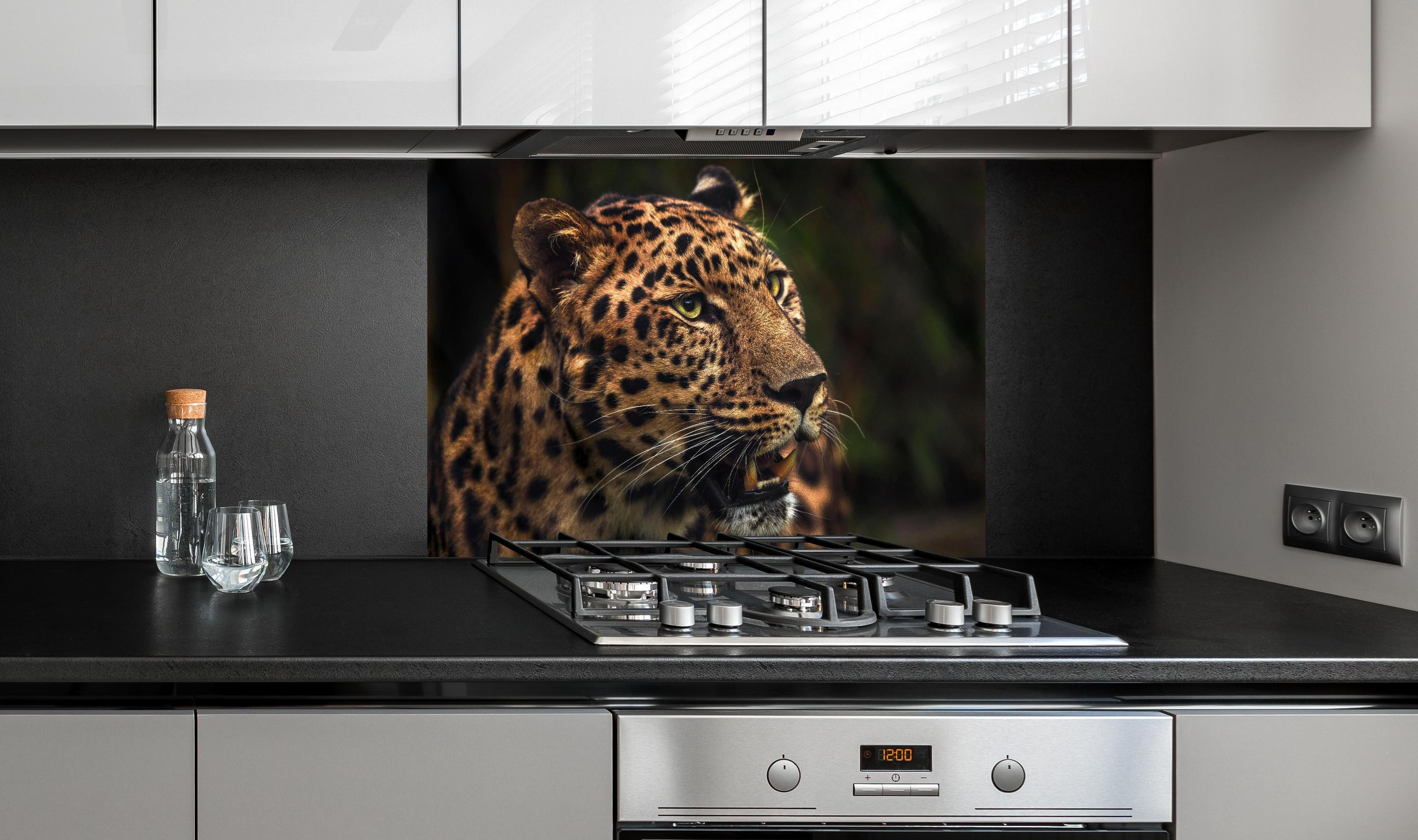 Spritzschutz - Majestätischer Amur-Leopard hinter einem Cerankochfeld zwischen Holz-Kochutensilien