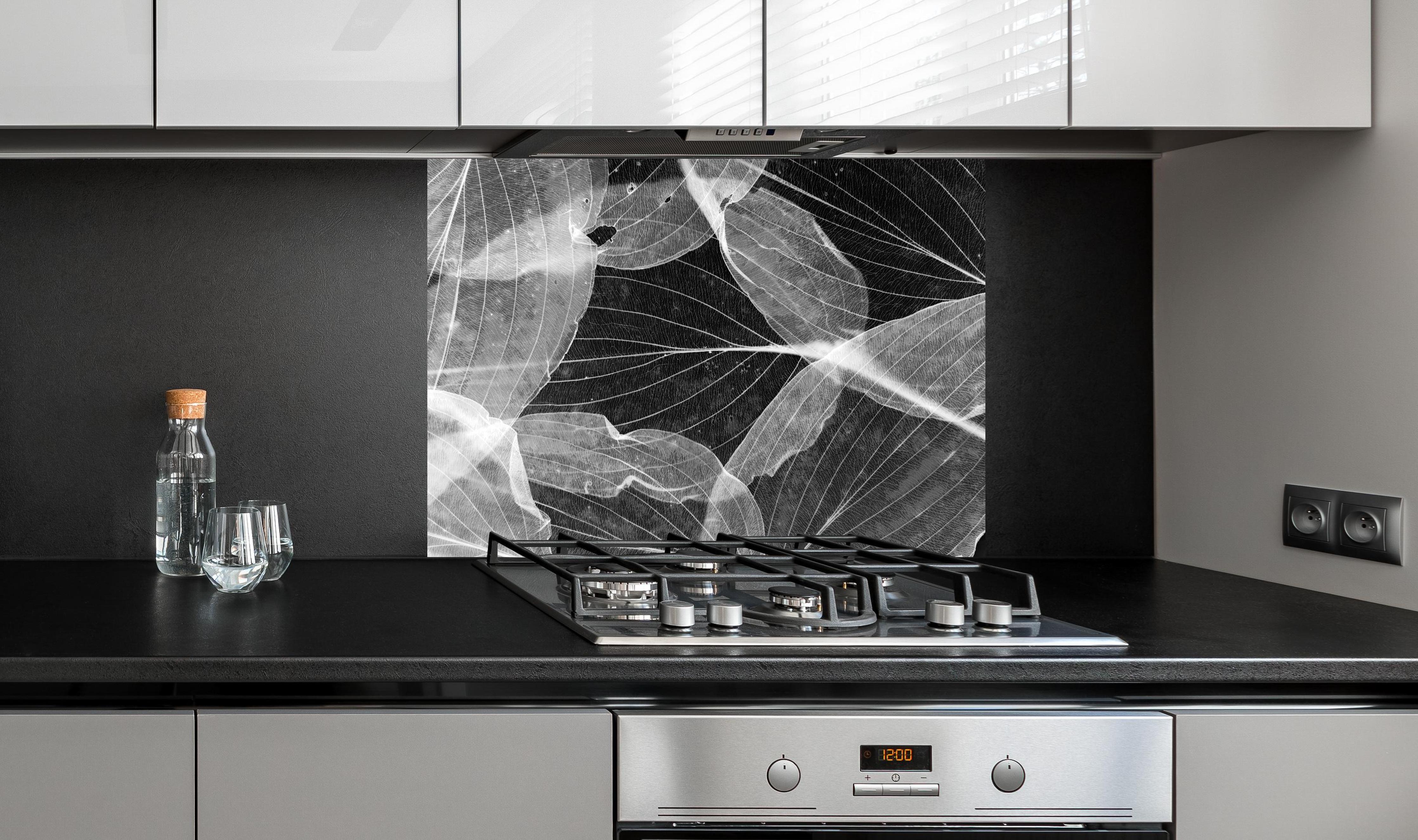 Spritzschutz - Makro-Textur Herbstblatt in Schwarz-Weiß hinter einem Cerankochfeld zwischen Holz-Kochutensilien