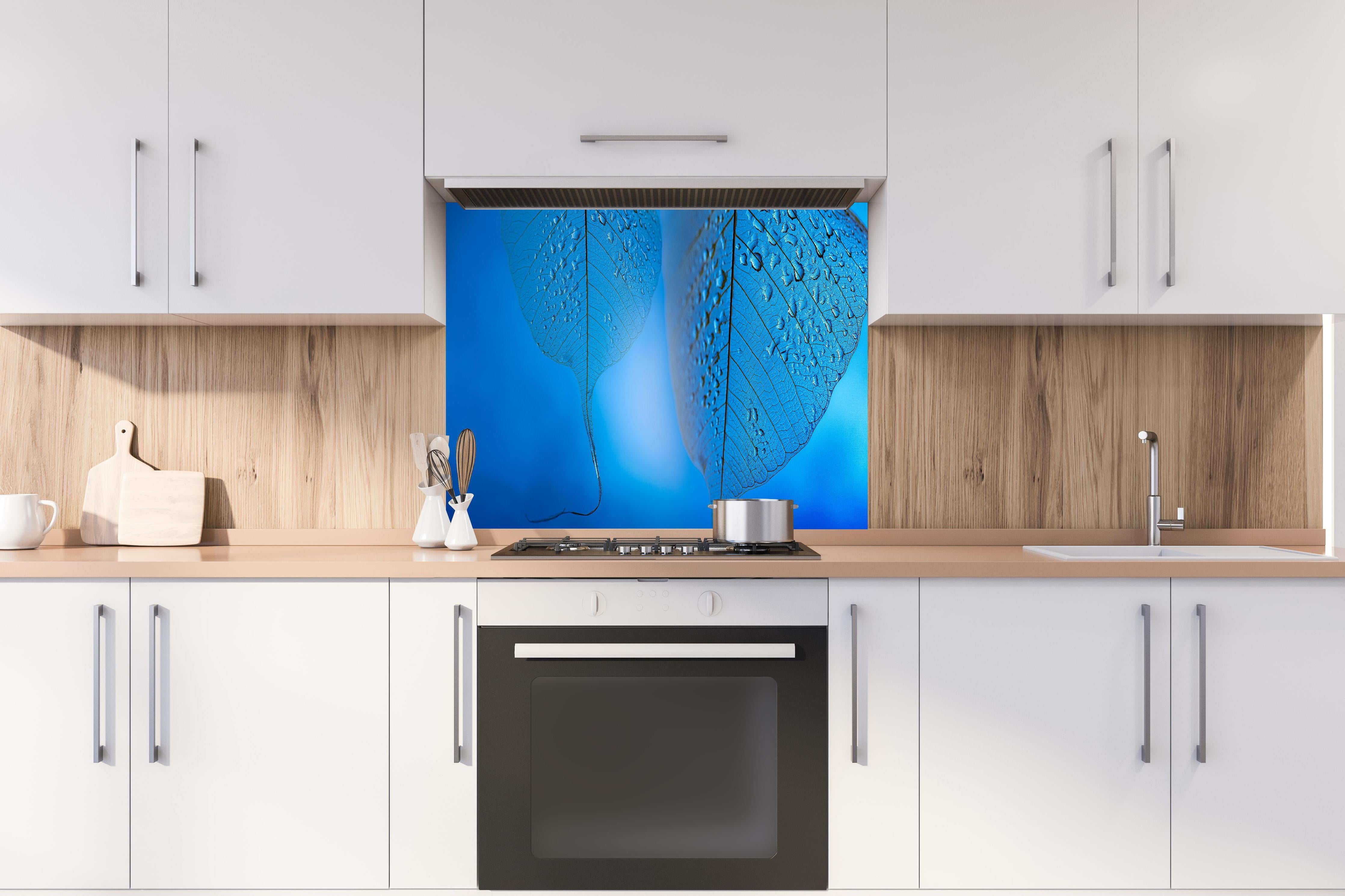 Spritzschutz - Makroaufnahme Blatt mit Tautropfen Blau hinter einem Cerankochfeld zwischen Holz-Kochutensilien