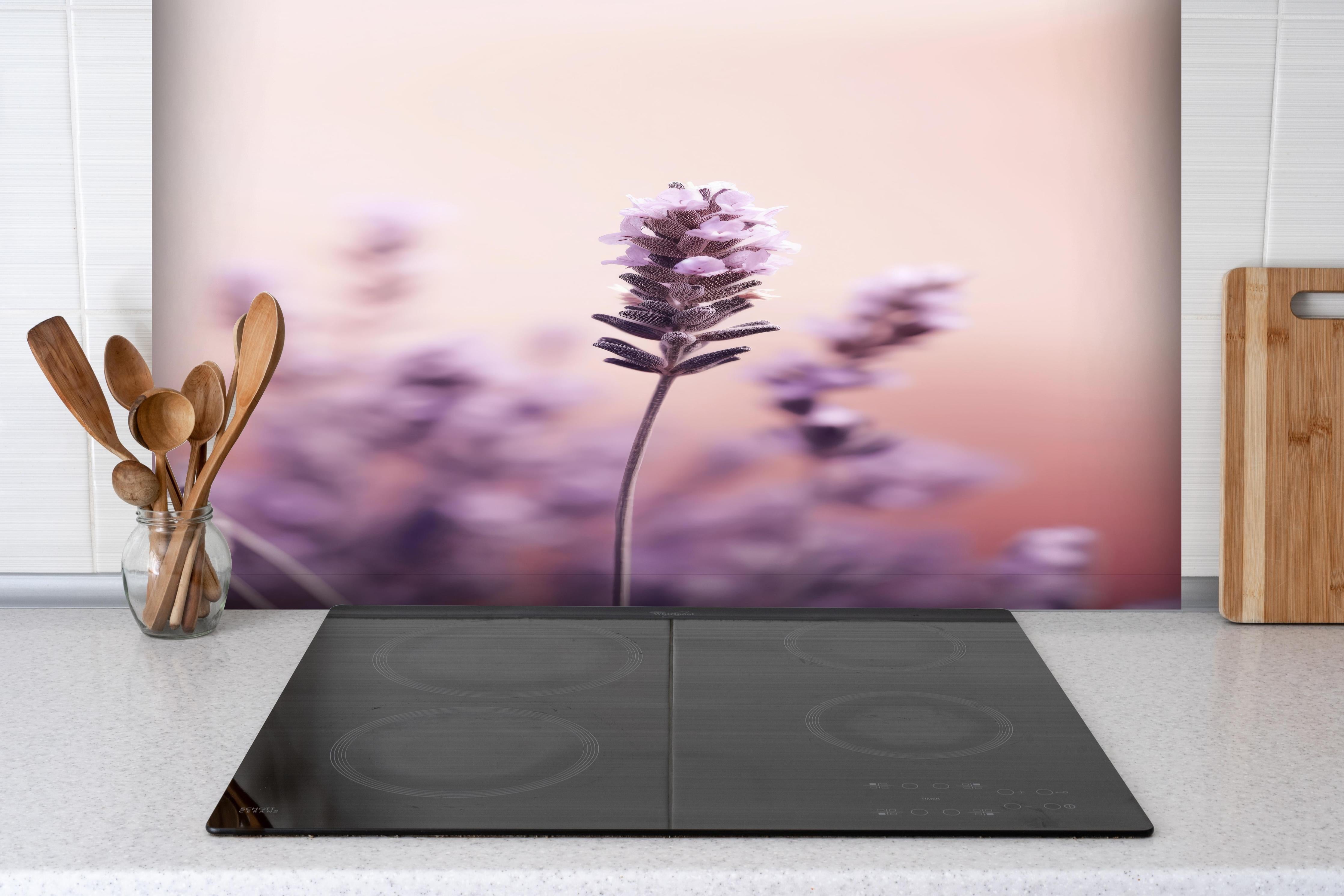 Spritzschutz - Makroaufnahme Lavendel in Pastellfarben hinter einem Cerankochfeld zwischen Holz-Kochutensilien