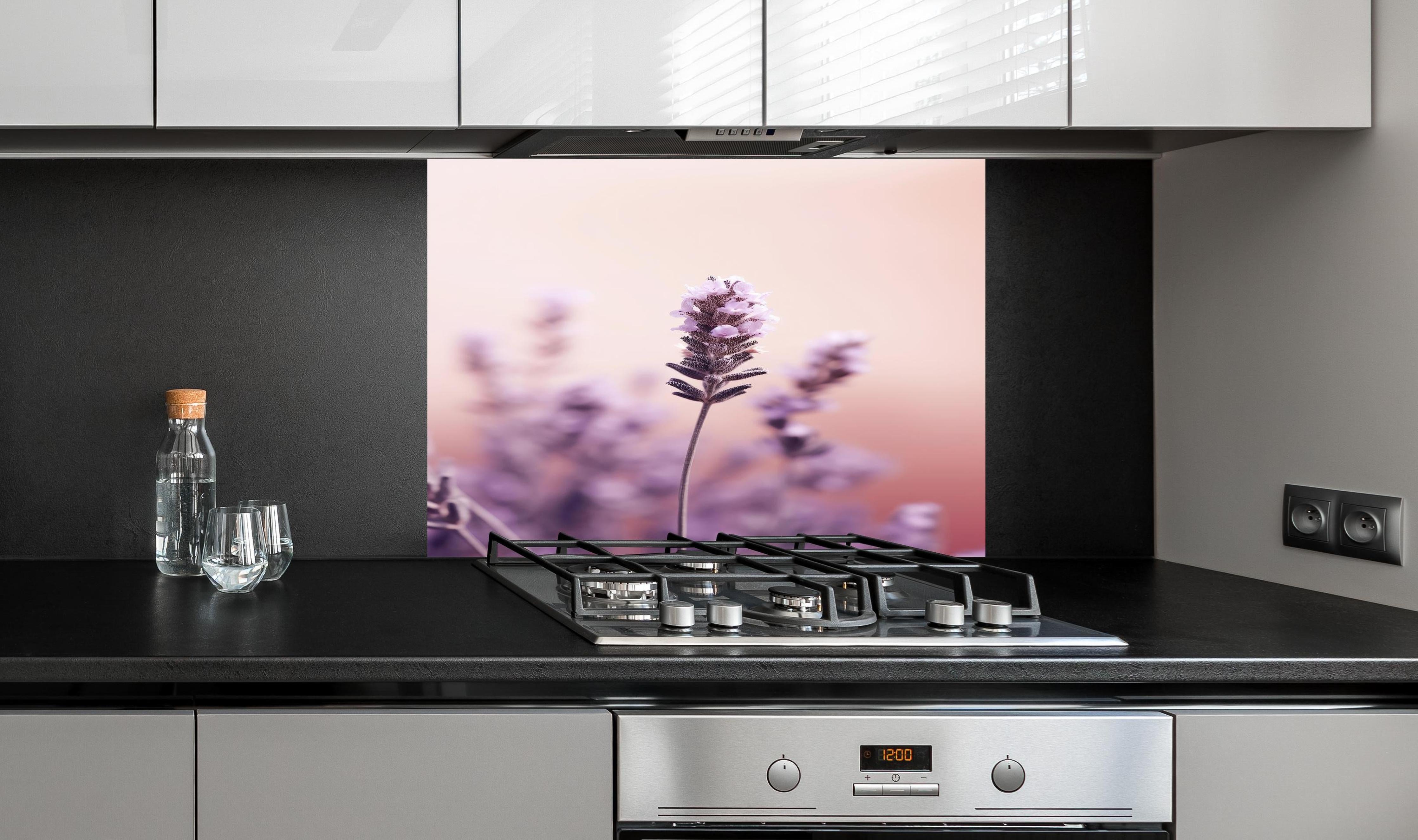 Spritzschutz - Makroaufnahme Lavendel in Pastellfarben hinter einem Cerankochfeld zwischen Holz-Kochutensilien