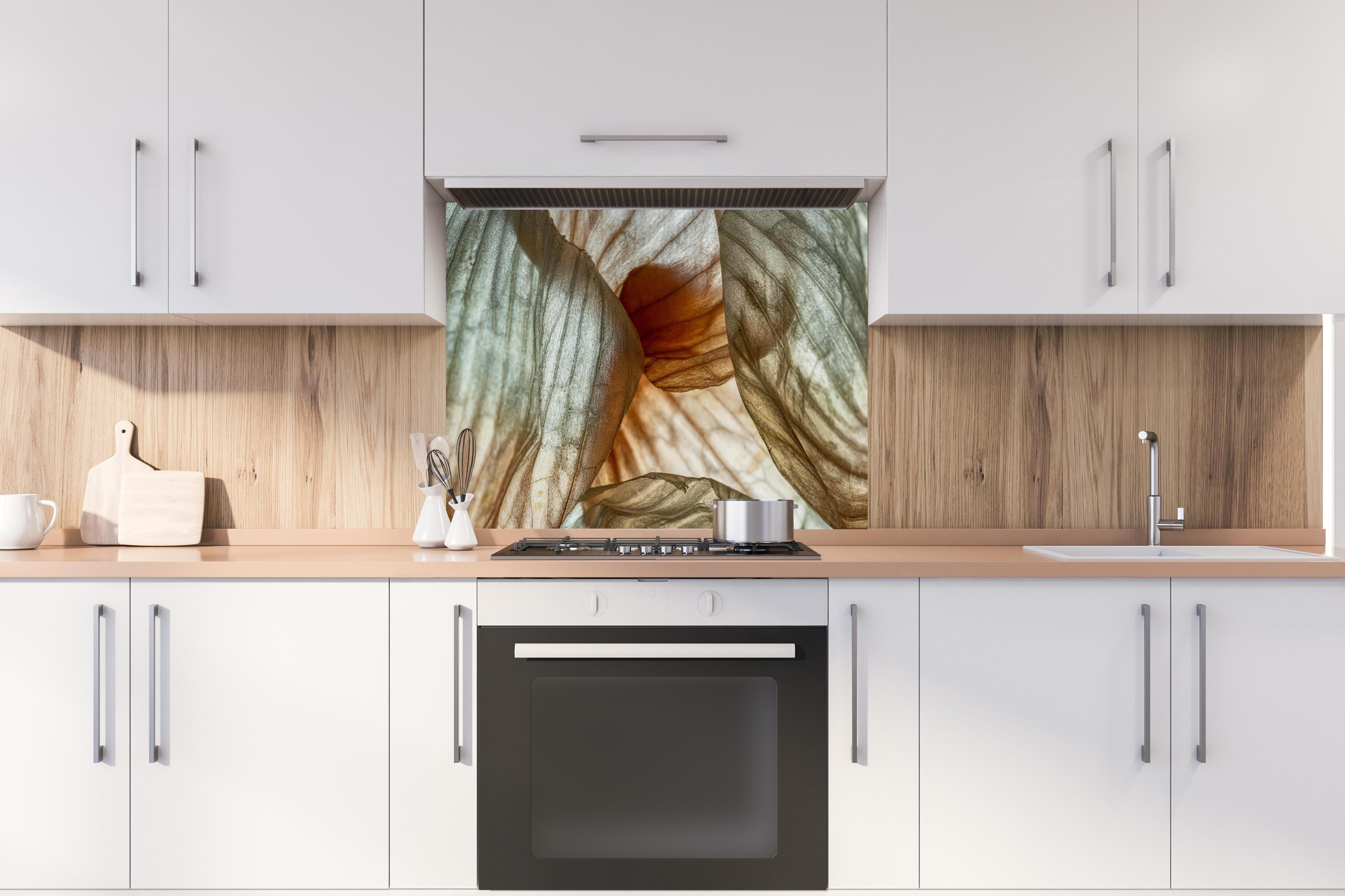 Spritzschutz - Makrofotografie der Schalenblatttextur einer Zwiebel hinter einem Cerankochfeld zwischen Holz-Kochutensilien