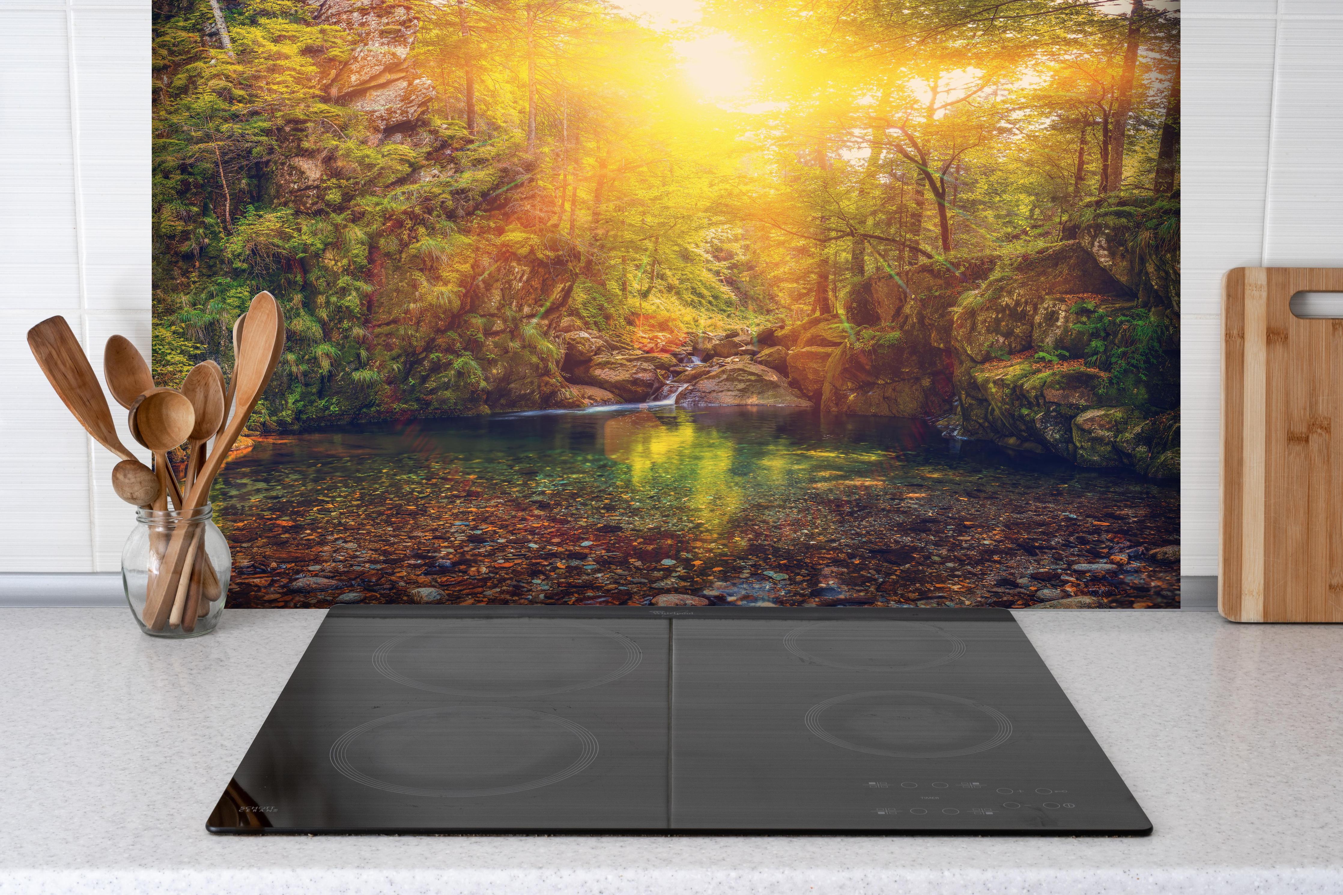 Spritzschutz - Malerischer Sonnenuntergang am Waldsee hinter einem Cerankochfeld zwischen Holz-Kochutensilien