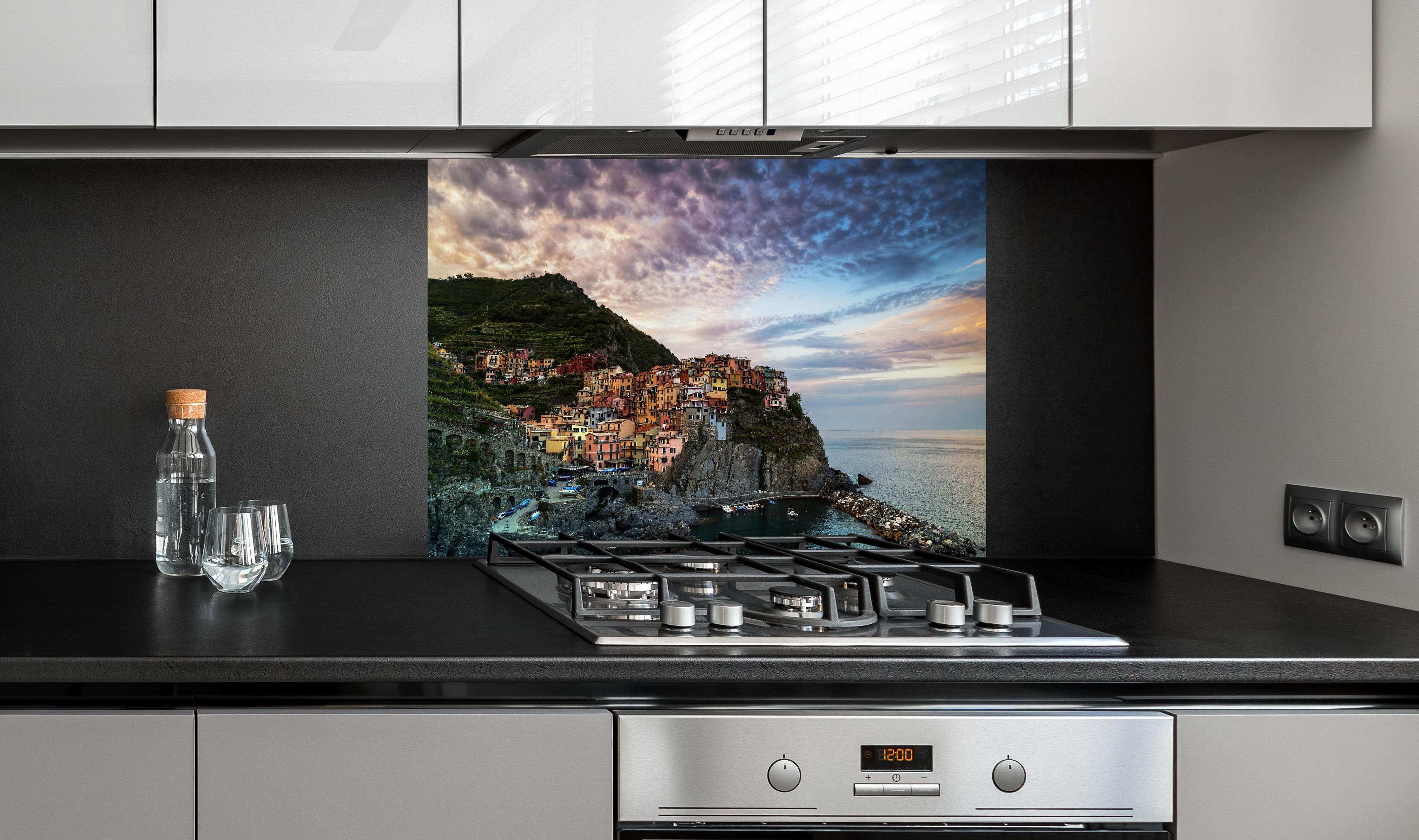 Spritzschutz - Manarola Italien Küstendämmerung hinter einem Cerankochfeld zwischen Holz-Kochutensilien